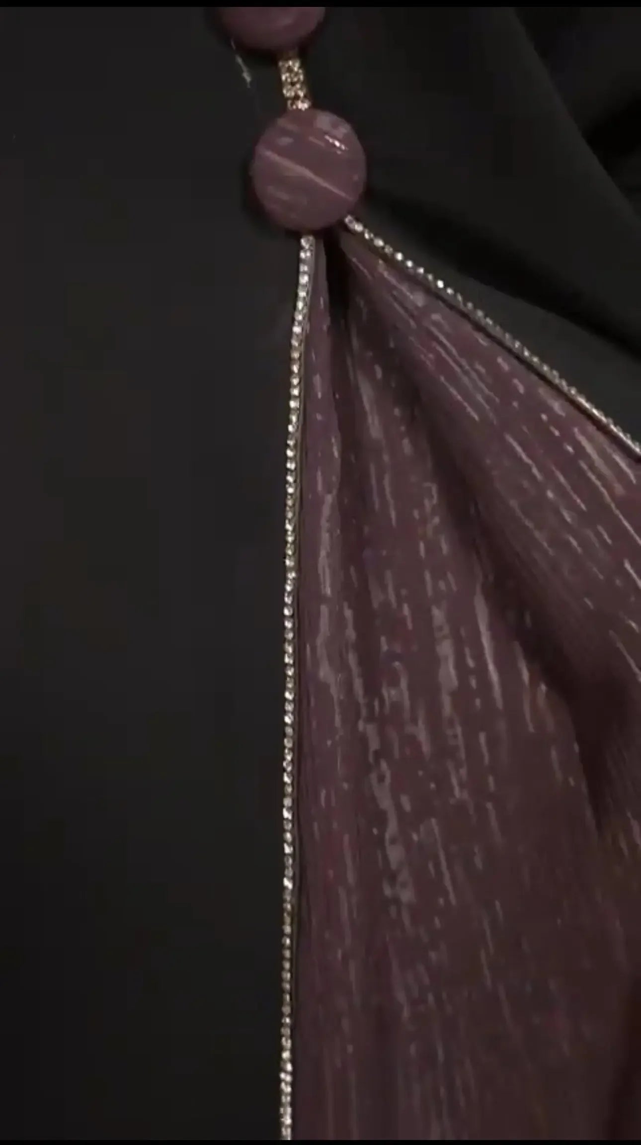 Close-up of elegant abaya for women with black fabric and decorative purple inner lining by Palestinian Elegance