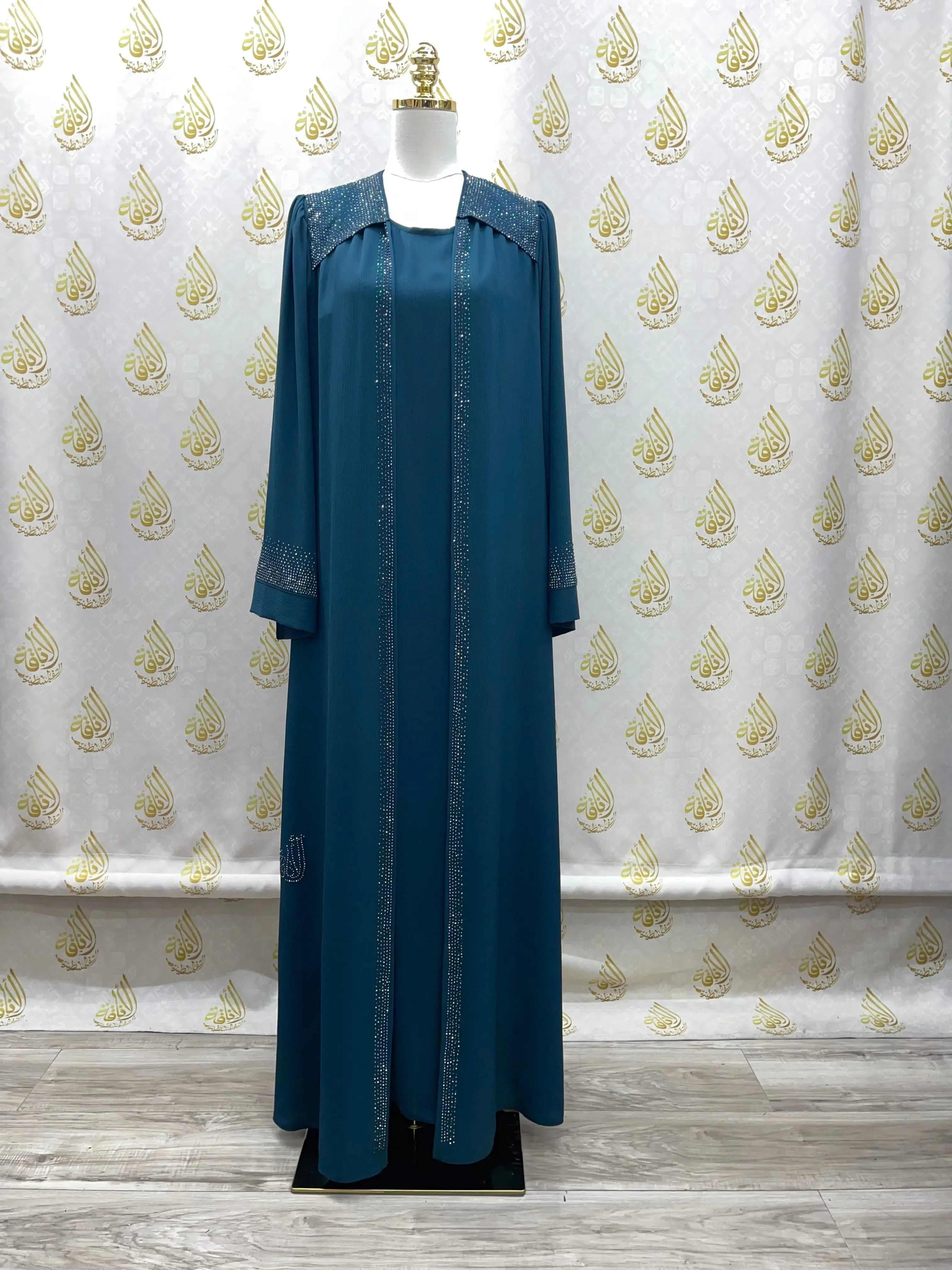 Elegant abaya with strass in teal blue displayed on mannequin from Palestinian Elegance