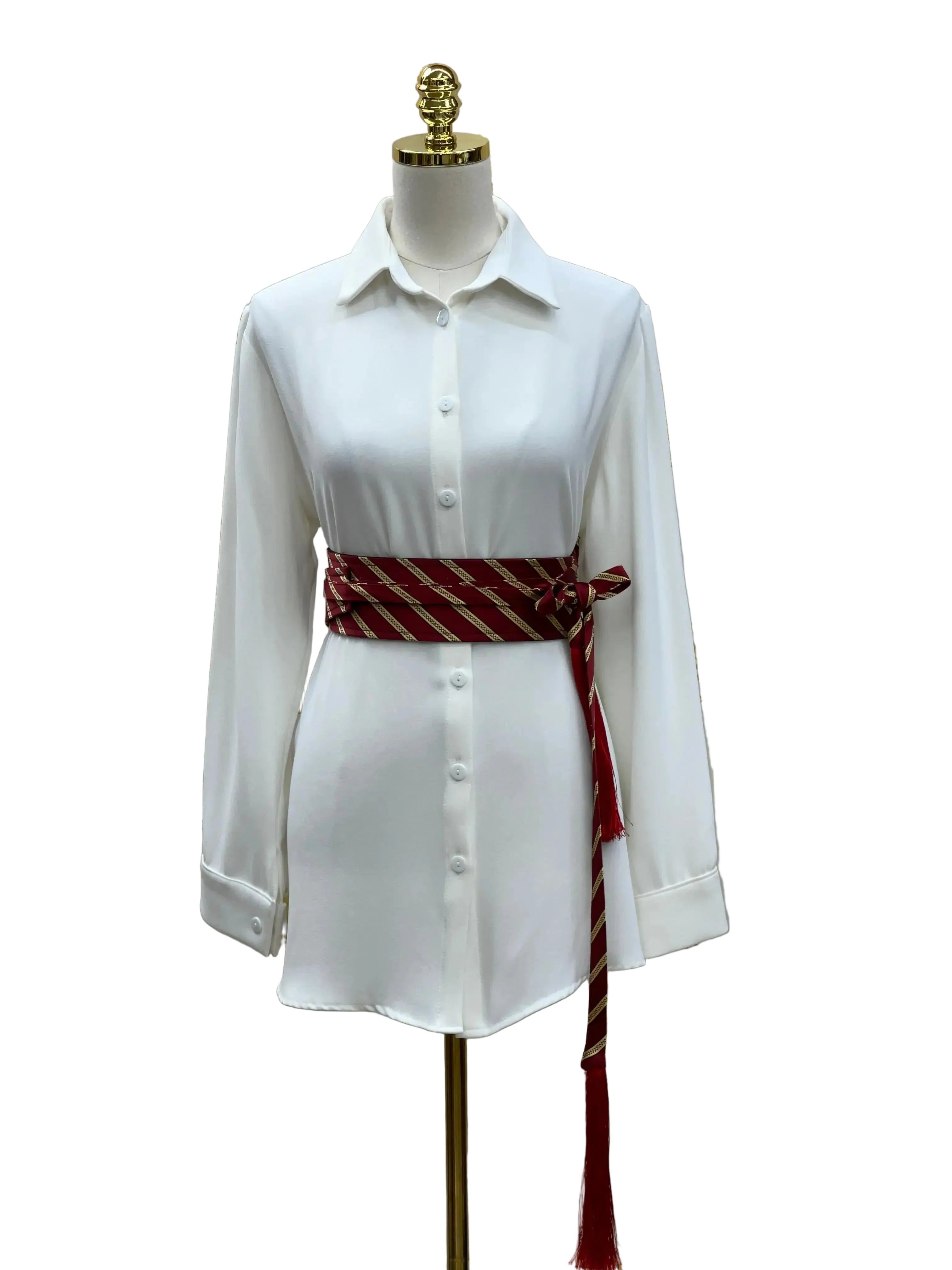 Embroidered kashmir belt in red and gold worn over white button-up shirt on mannequin