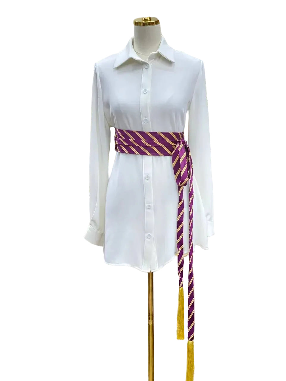 Embroidered kashmir belt in purple and gold stripes tied around a white shirt dress by Palestinian Elegance