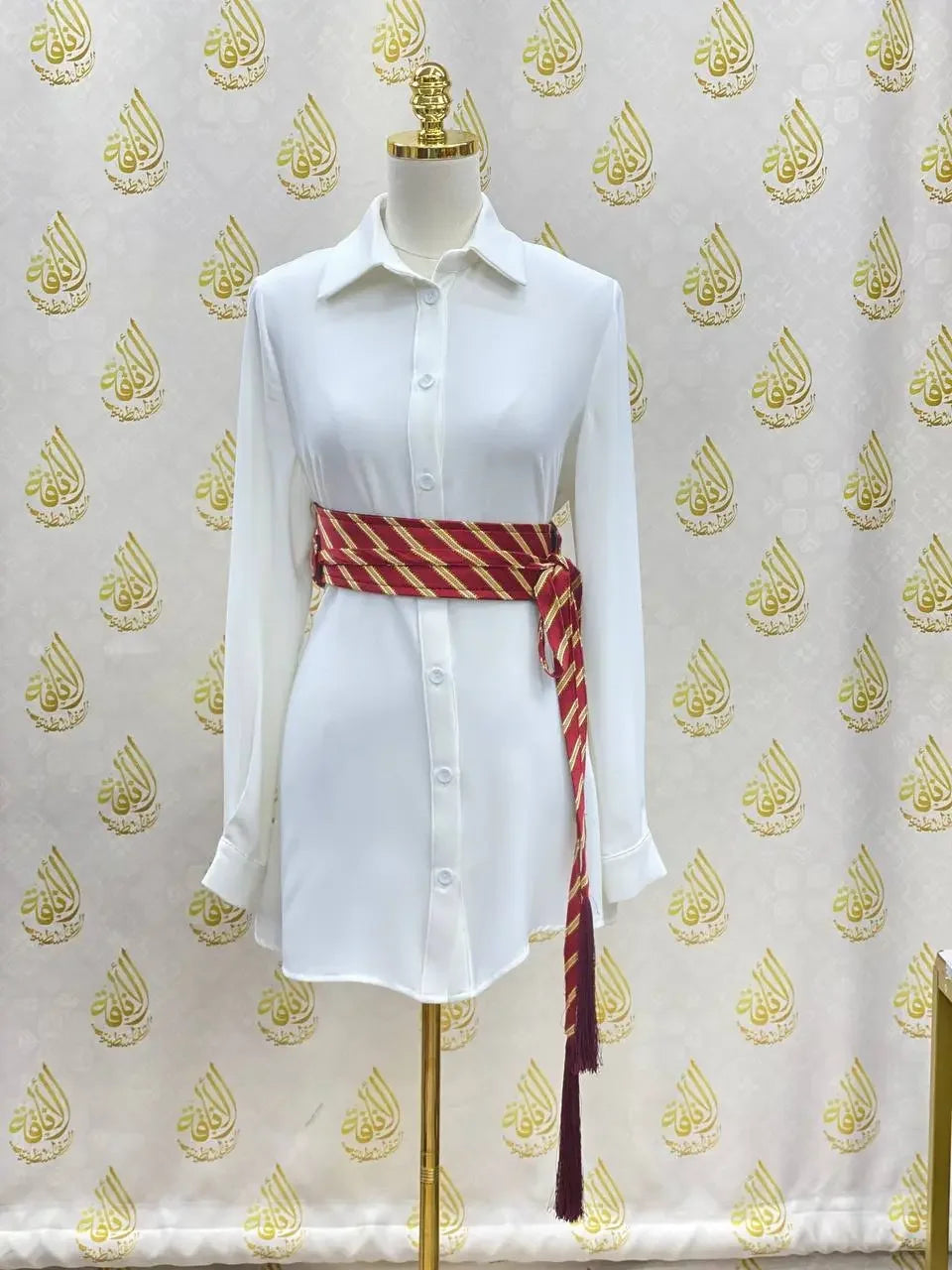 White long sleeve shirt styled with a red and gold embroidered kashmir belt around the waist