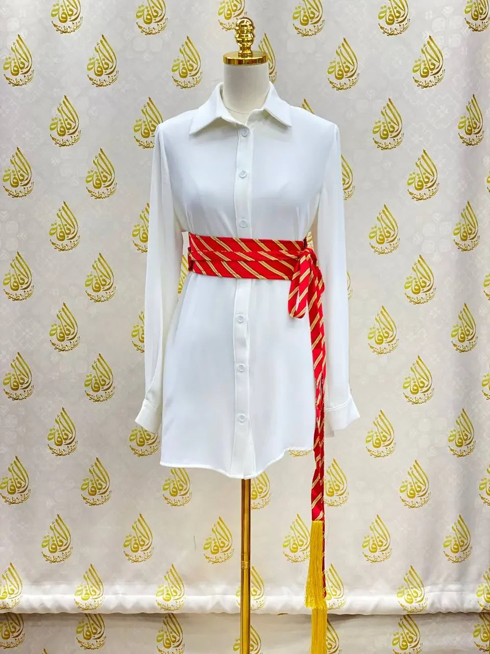 White dress styled with a red and gold embroidered kashmir belt wrapped around the waist