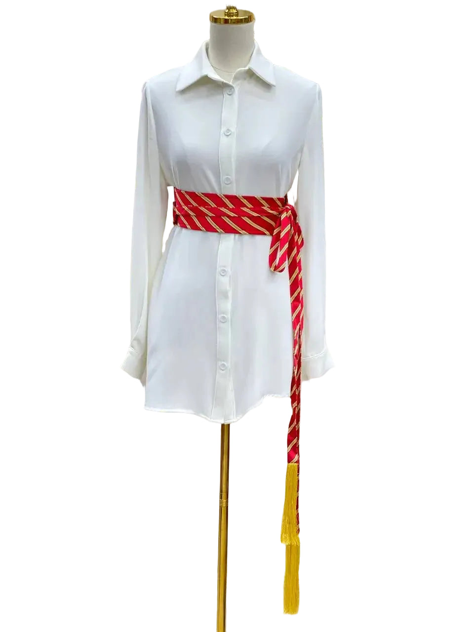 Embroidered kashmir belt in red and gold wrapped around white shirt dress on mannequin