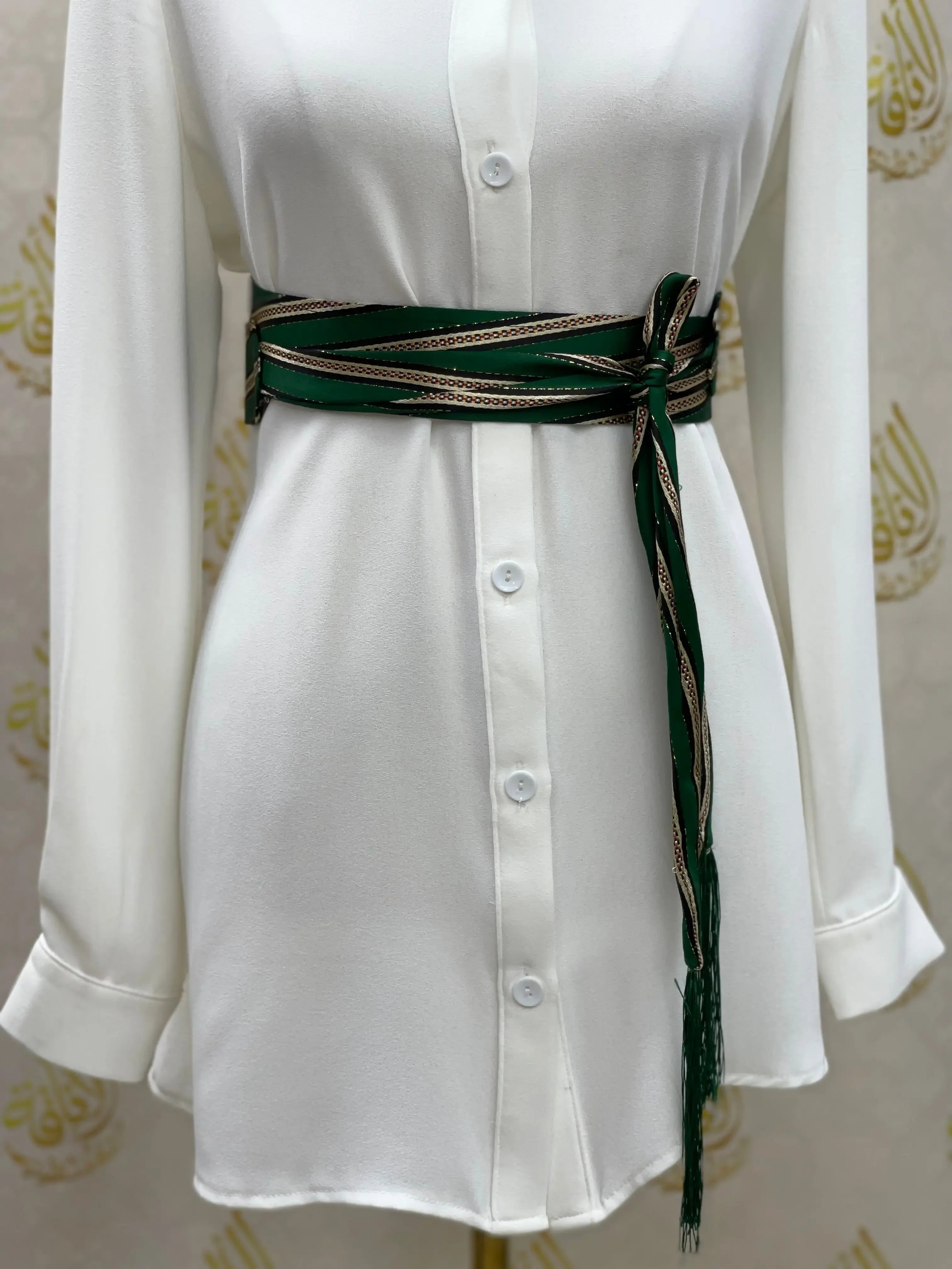 Embroidered saya belt by Palestinian Elegance wrapped around a white button-up dress