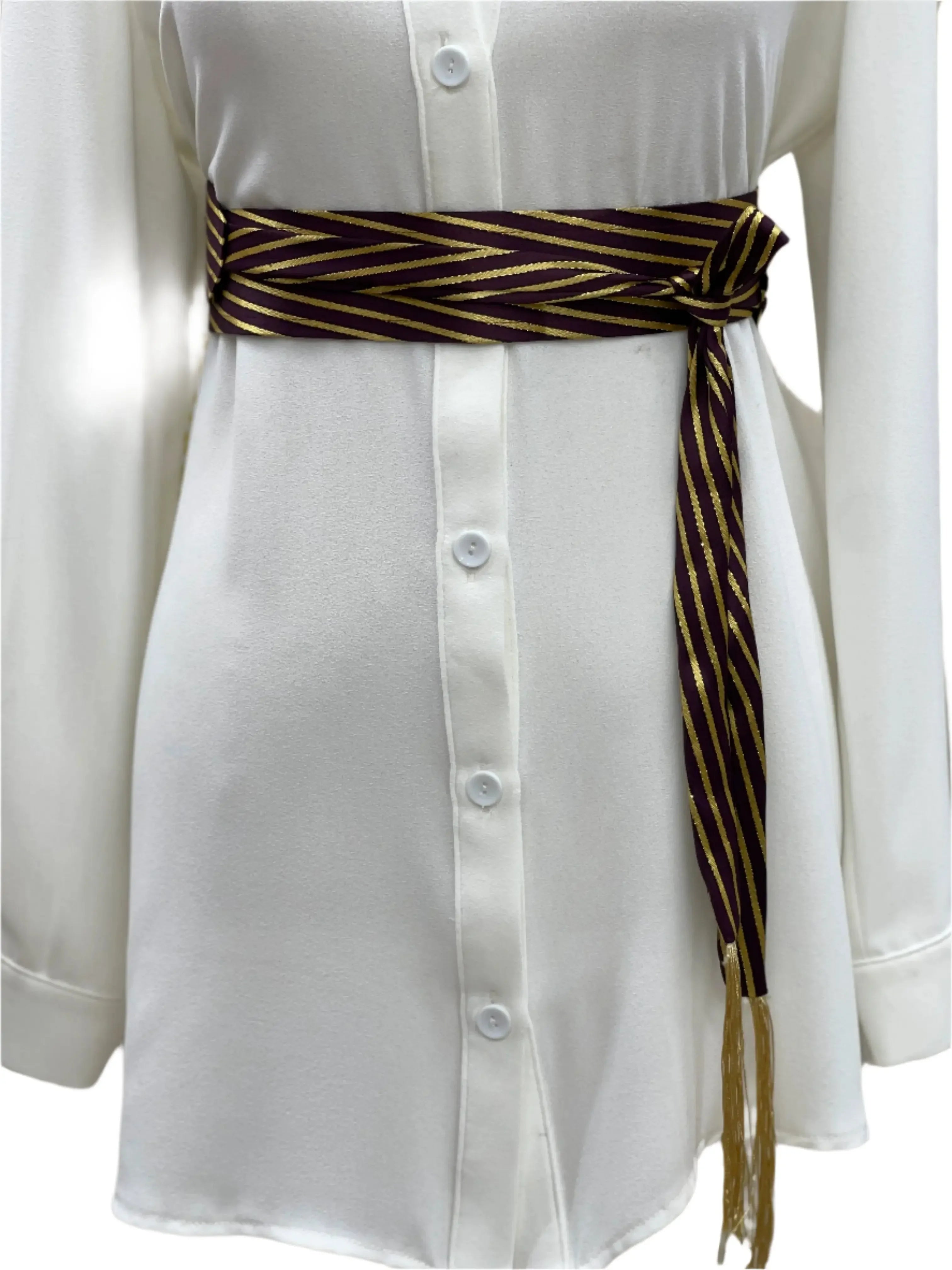 Embroidered saya belt in purple and gold striped pattern wrapped around white buttoned dress