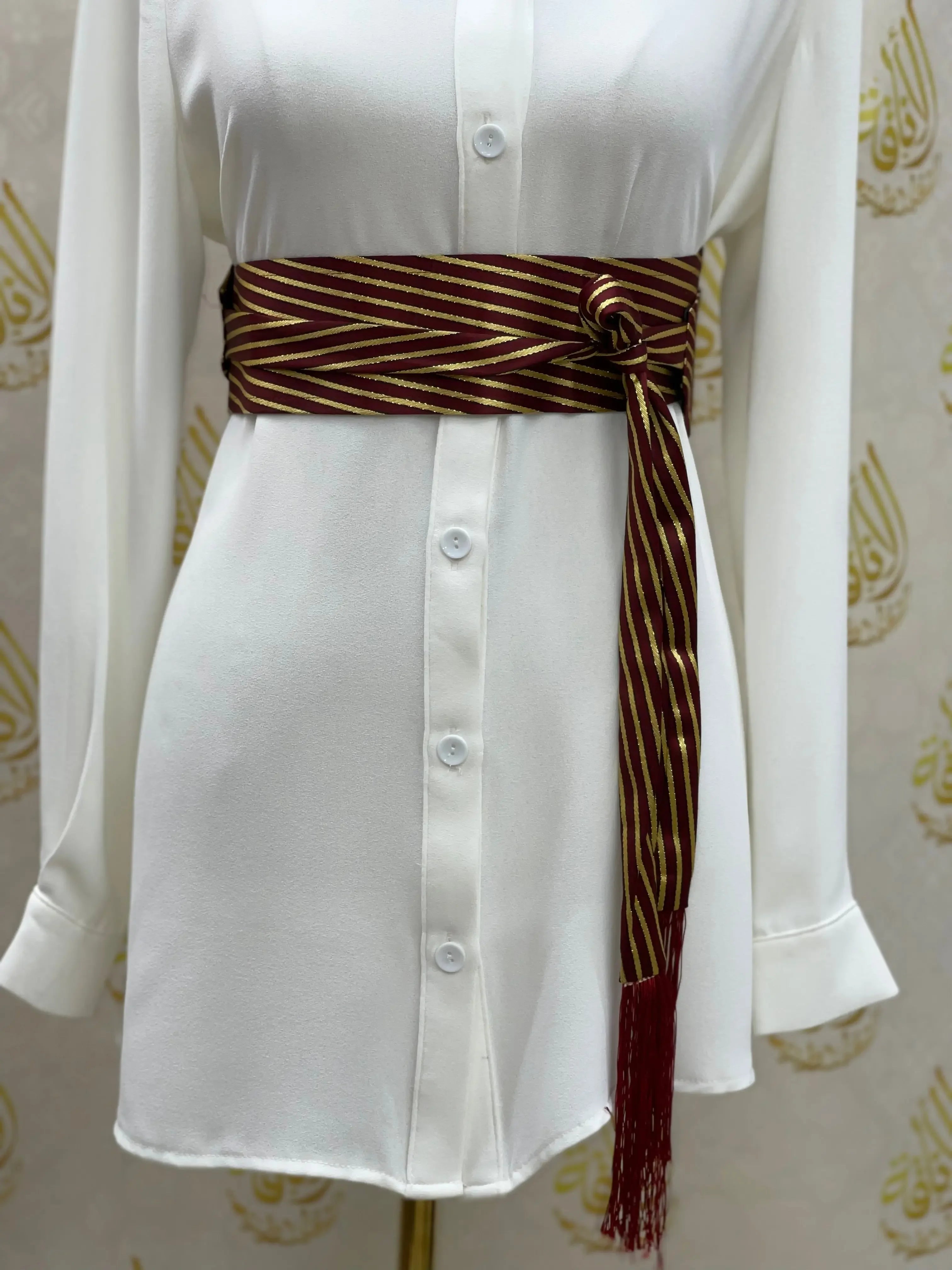Embroidered waist belt for women by Palestinian Elegance in red and gold worn over white dress