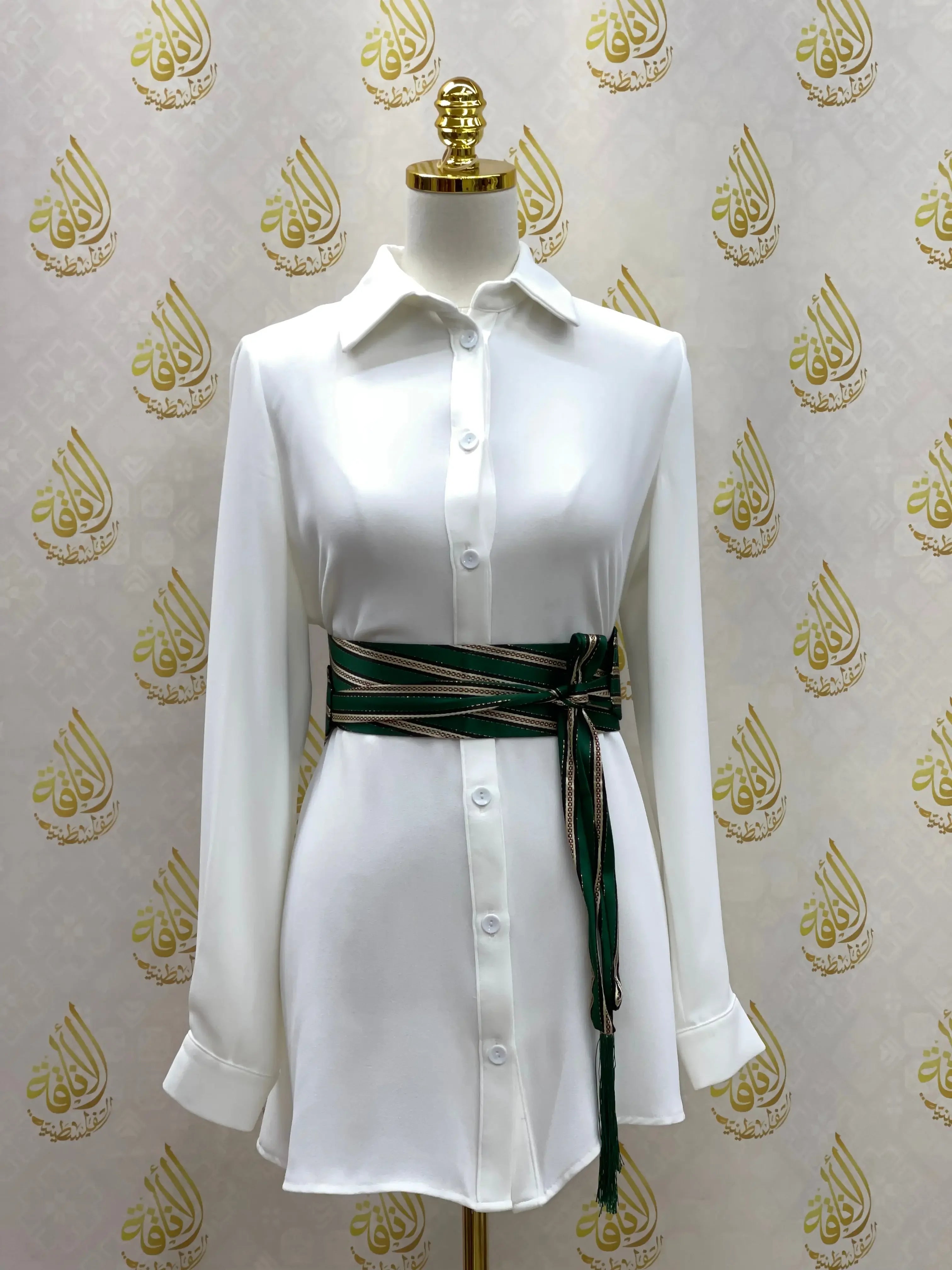 Embroidered waist belt for women in green and black wrapped around white button-down dress