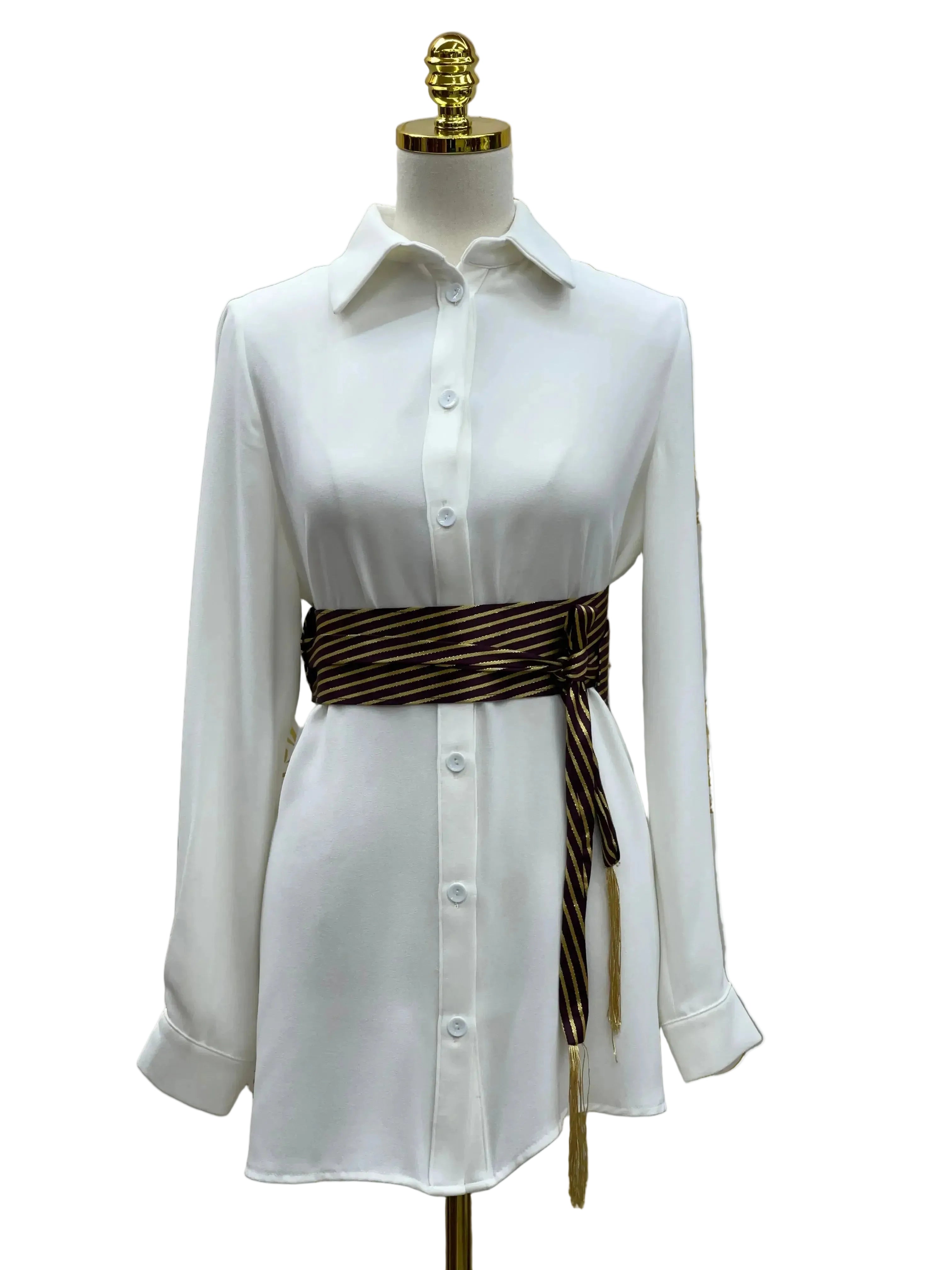 Embroidered waist belt for women in black and gold worn over a white button-down dress