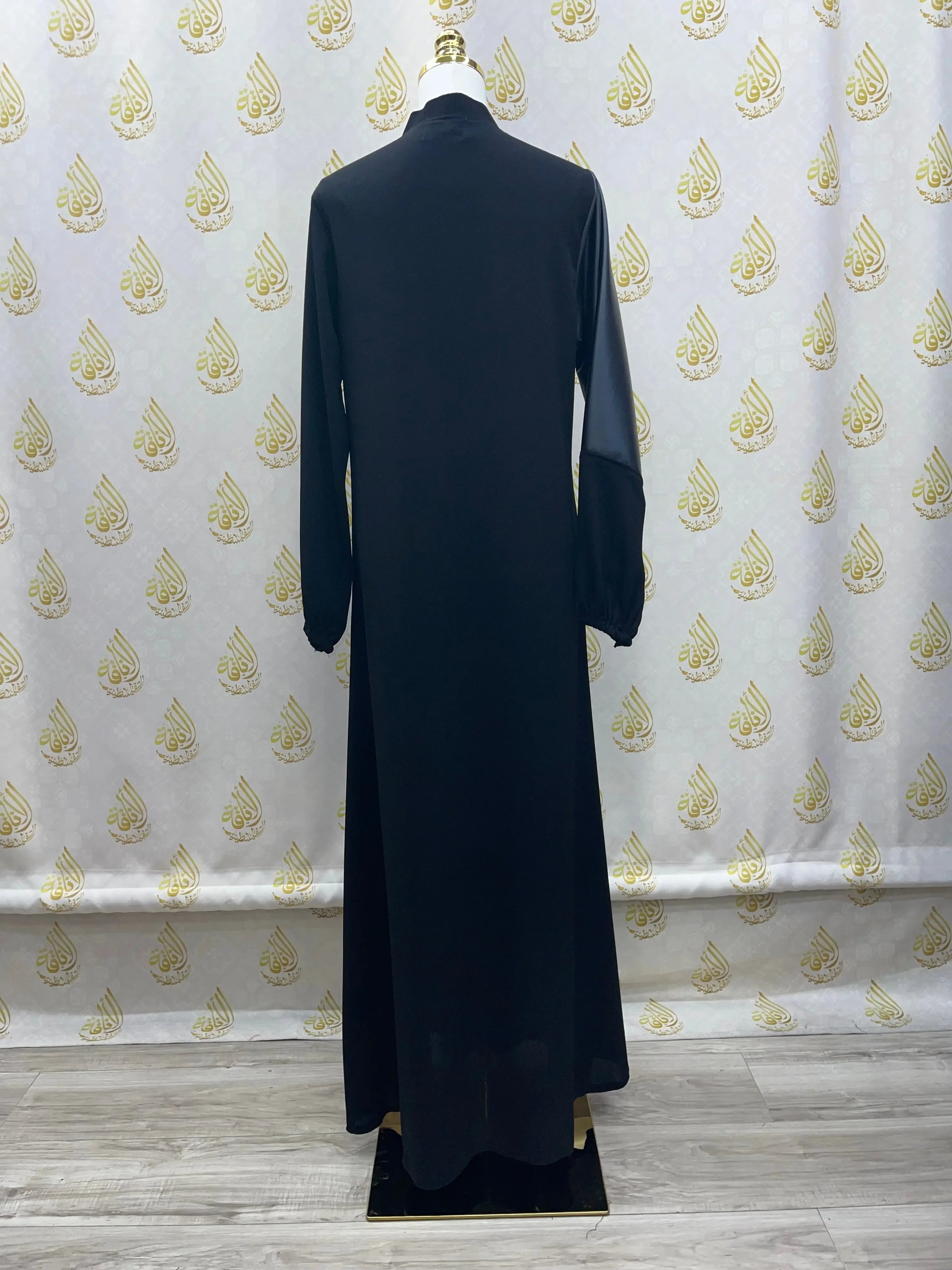 Back view of a black luxury women leather abaya by Palestinian Elegance displayed on a mannequin