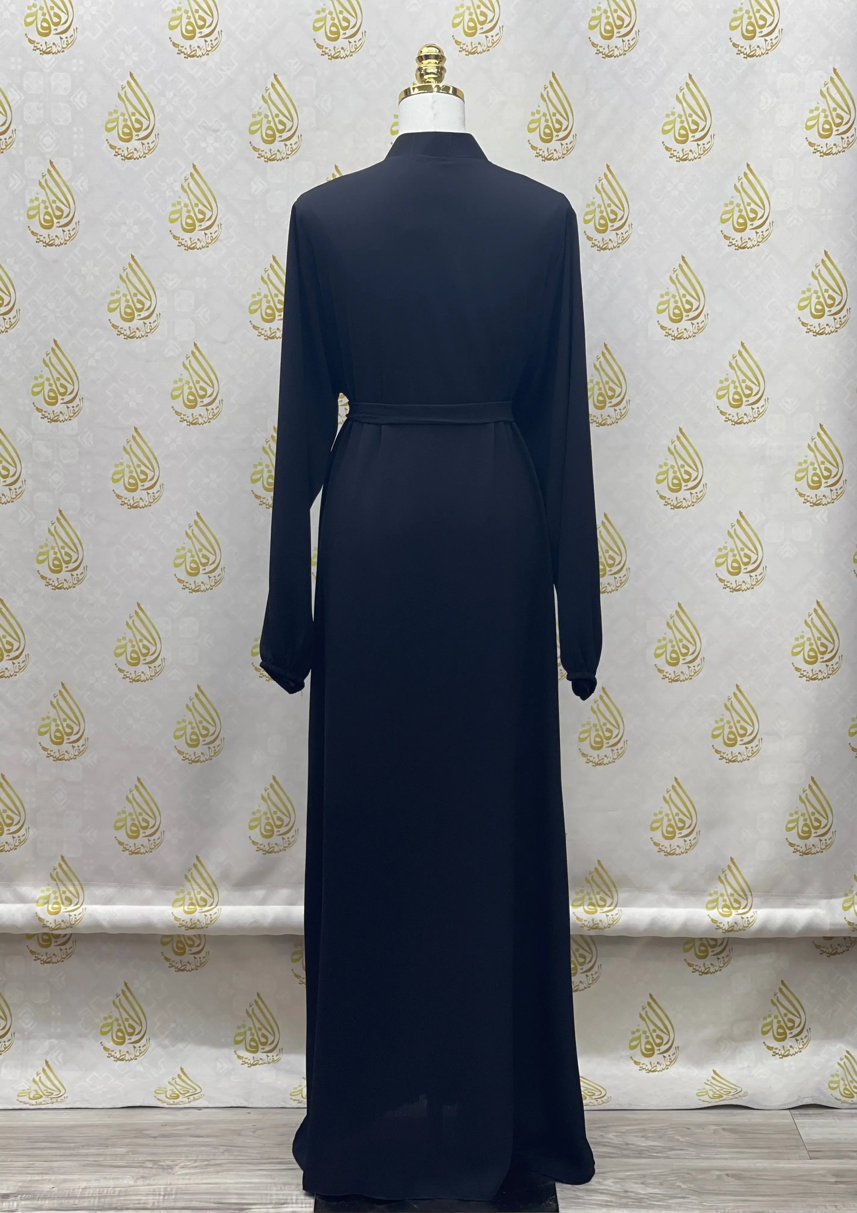 Back view of plain black abaya from Palestinian Elegance with long sleeves and a belted waist