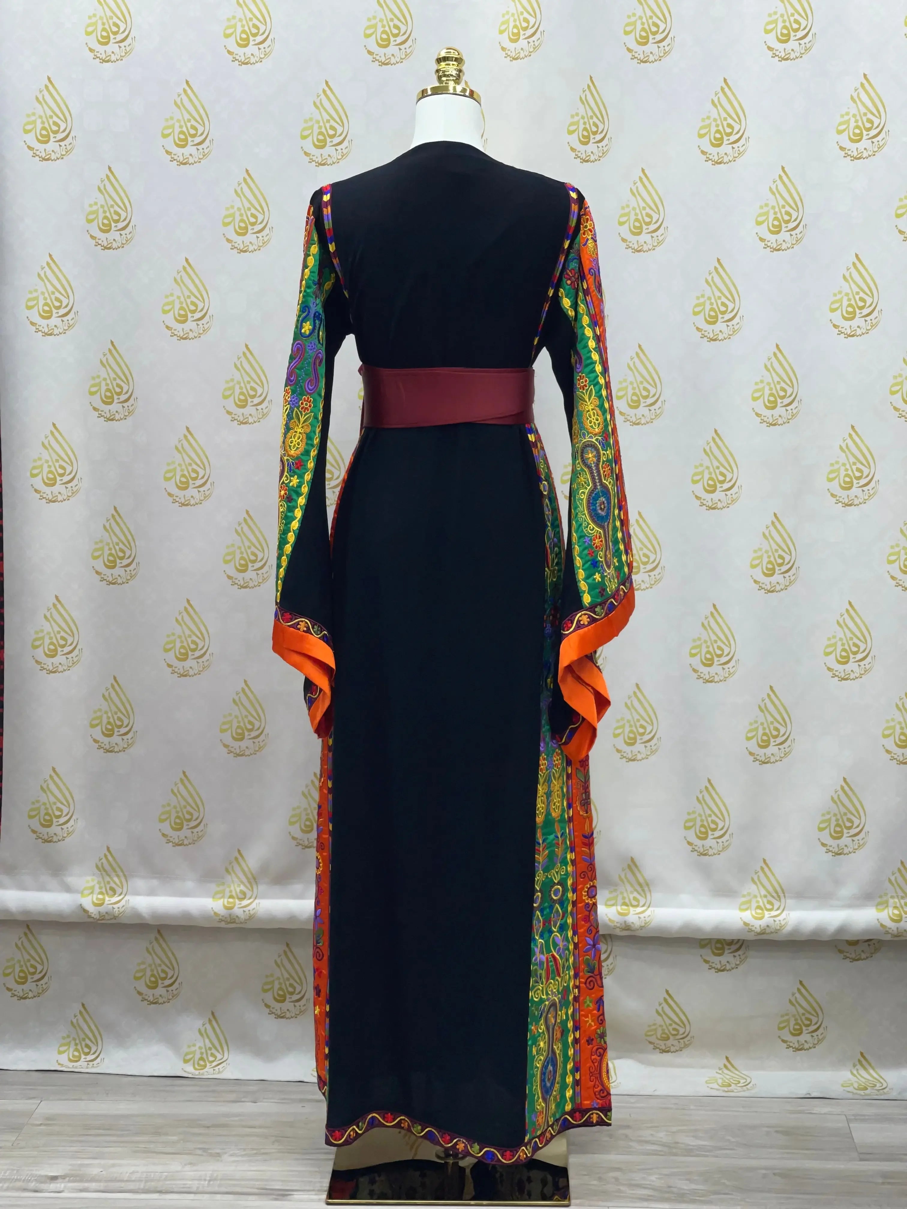 Palestinian Elegance embroidered black dress with colorful patterned sleeves and red waist belt