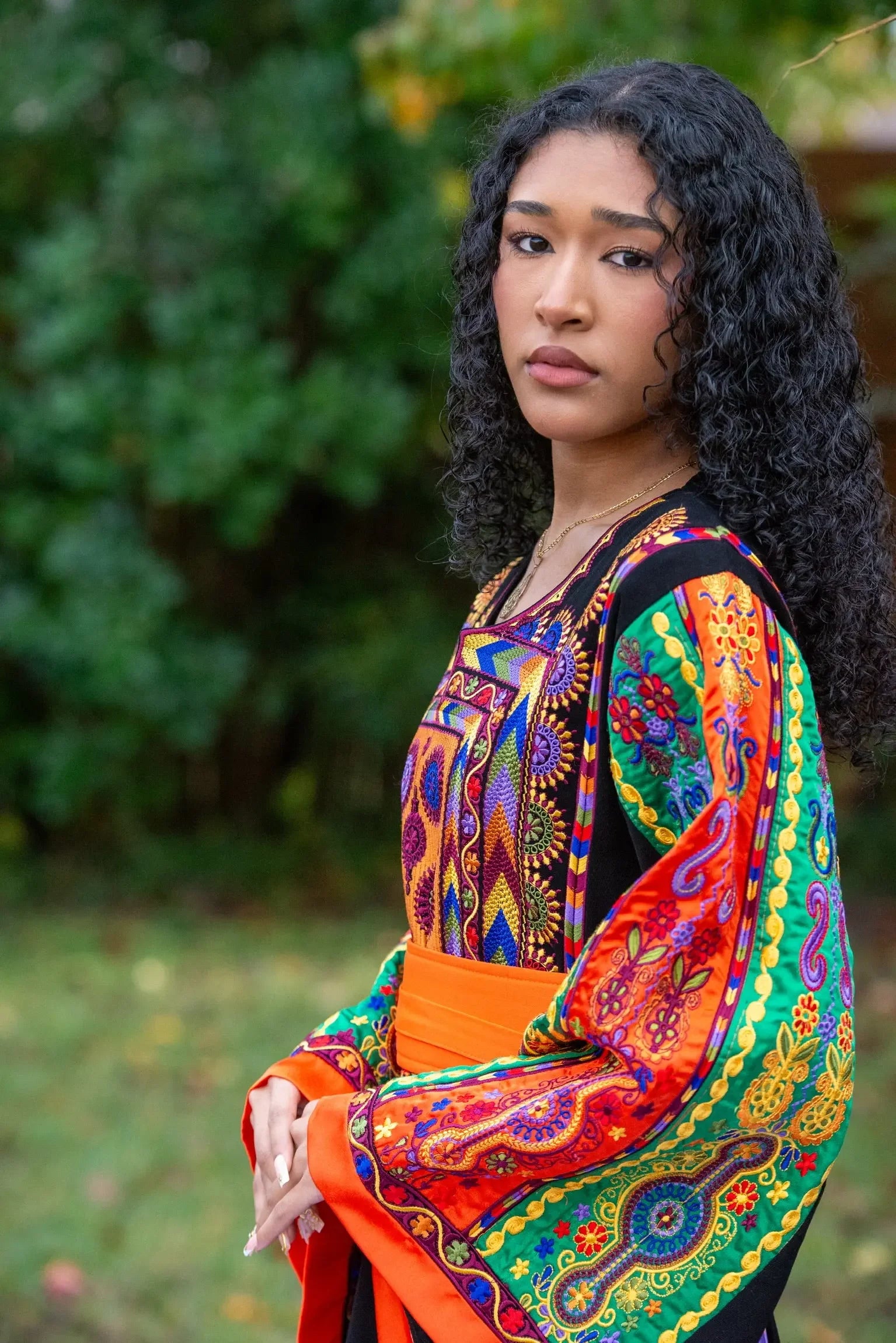 Woman wearing colorful Palestinian Elegance embroidered traditional dress with intricate vibrant patterns