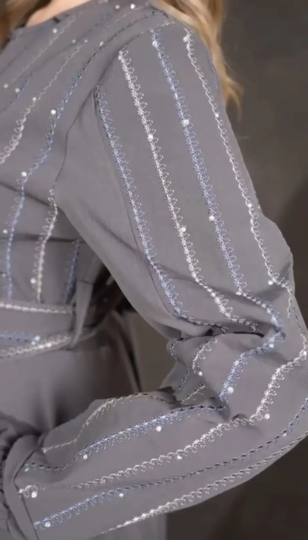 Close-up of Palestinian Elegance gray versatile abaya dress with intricate silver sequin stripes on sleeves