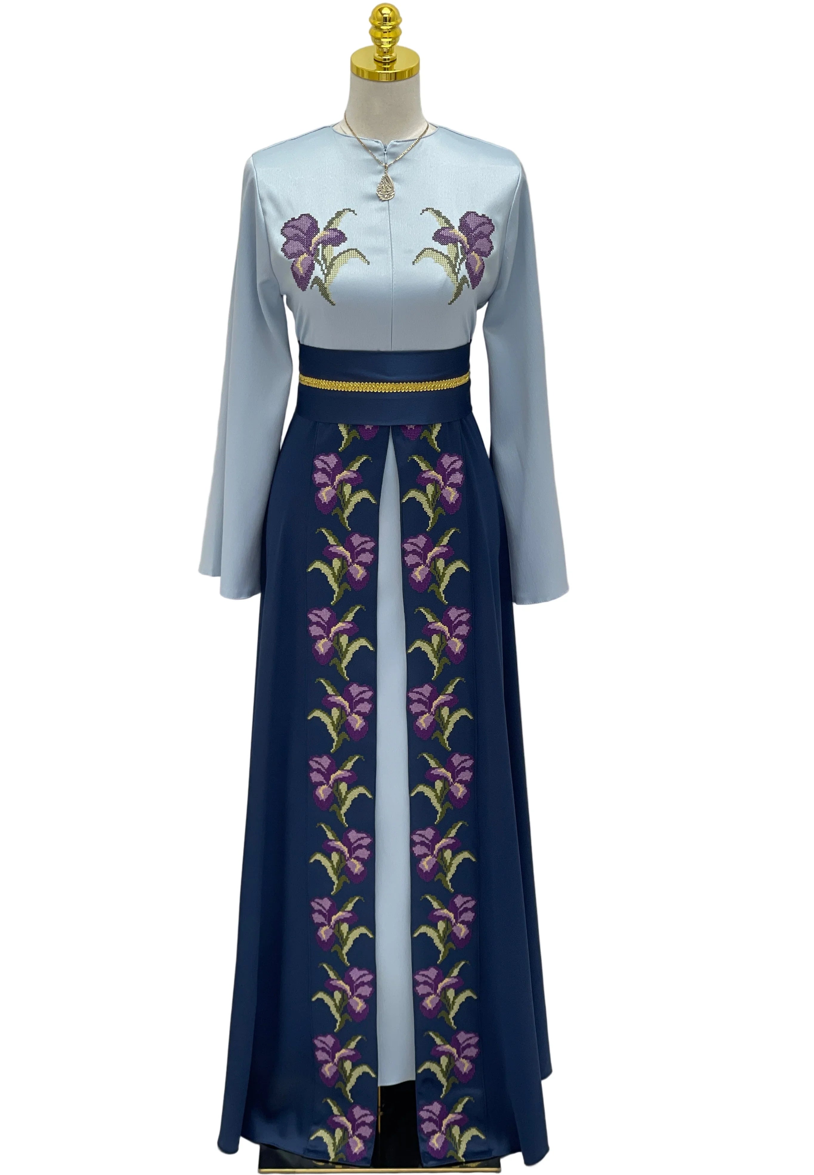Mannequin wearing a light blue top and dark blue skirt with floral embroidery on a white background.