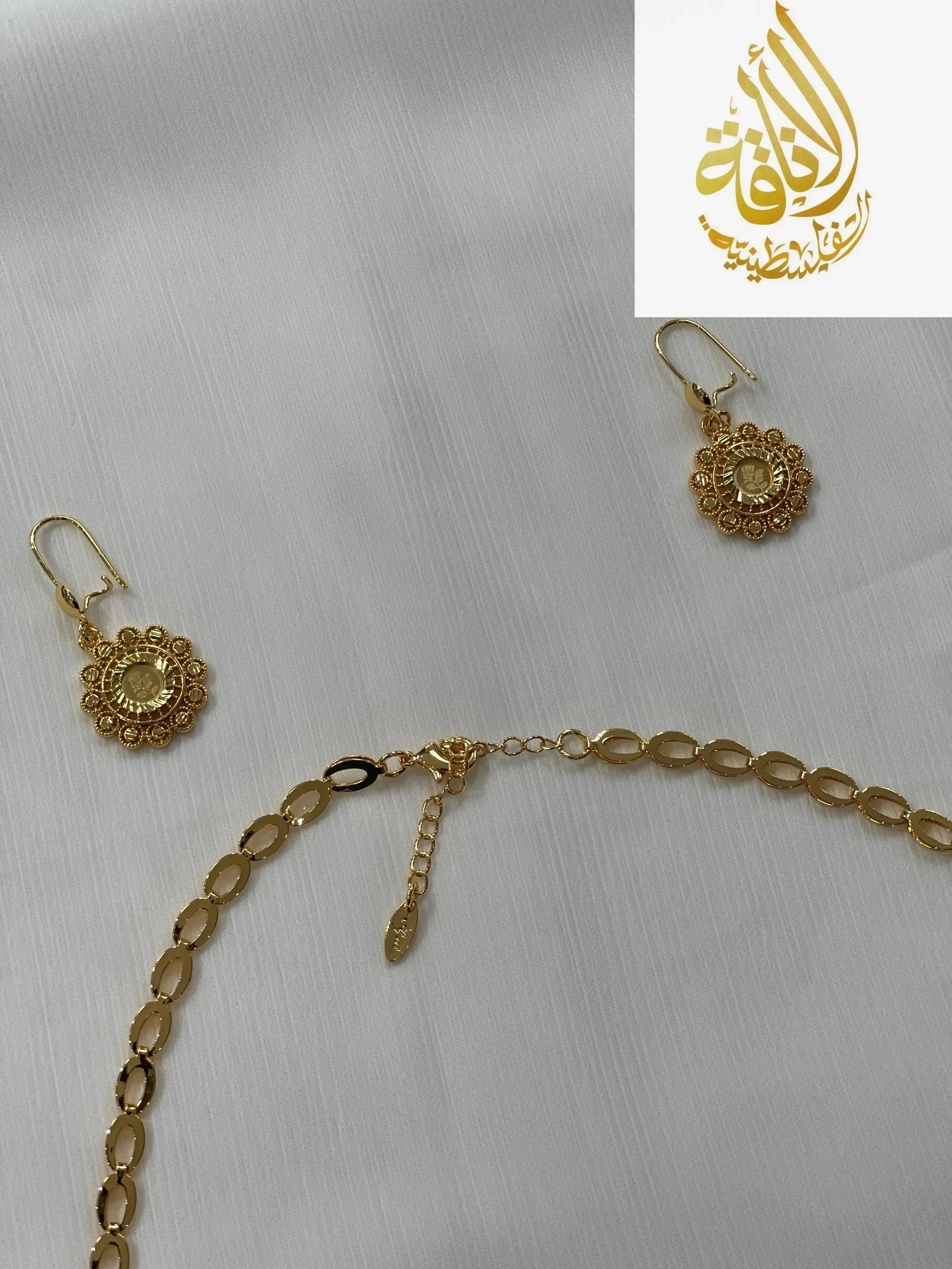 Gold jewelry set for women including intricate gold earrings and a matching linked chain necklace