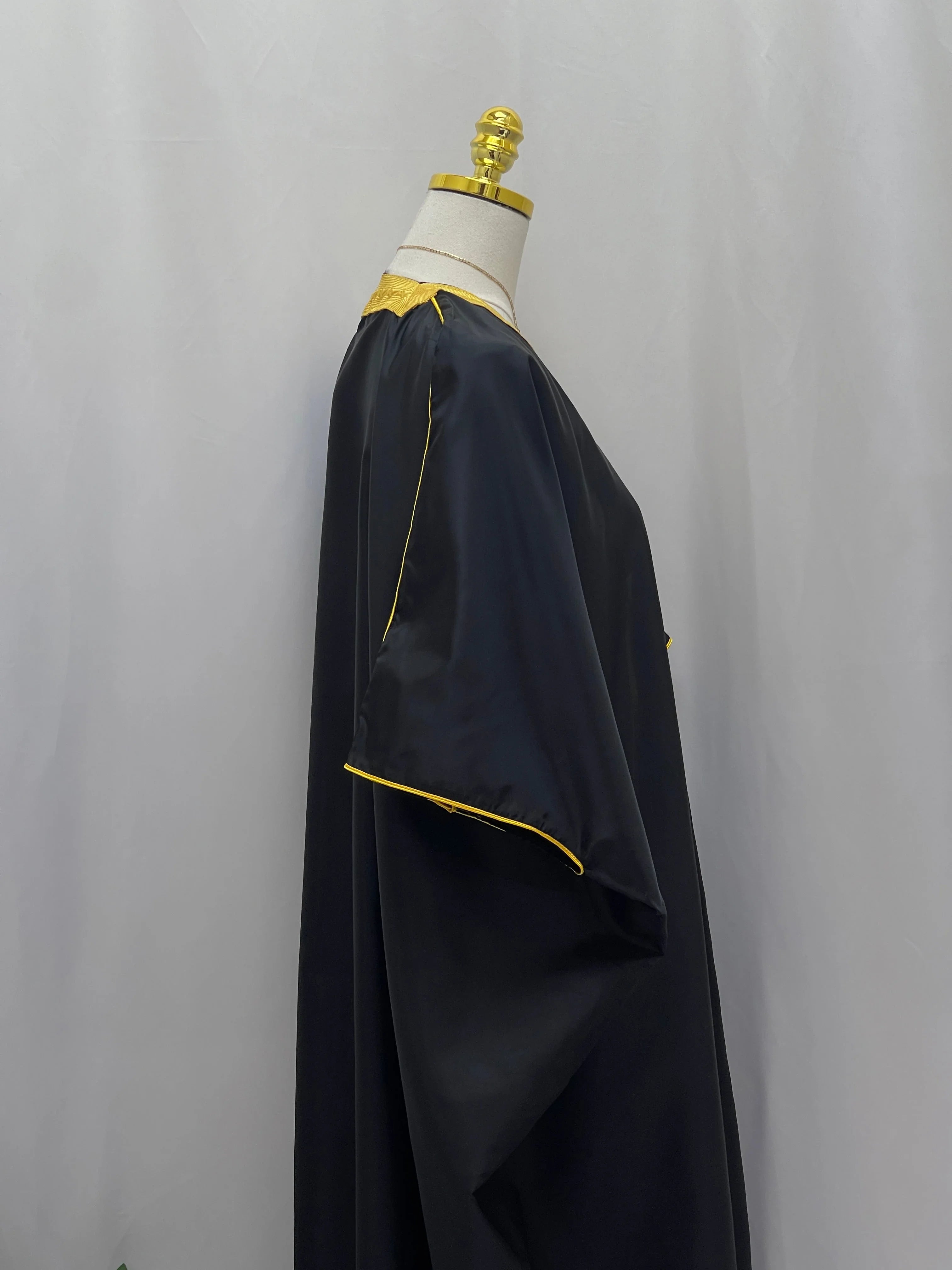 Mens Black Bisht with Golden Trim displayed elegantly on a mannequin side view