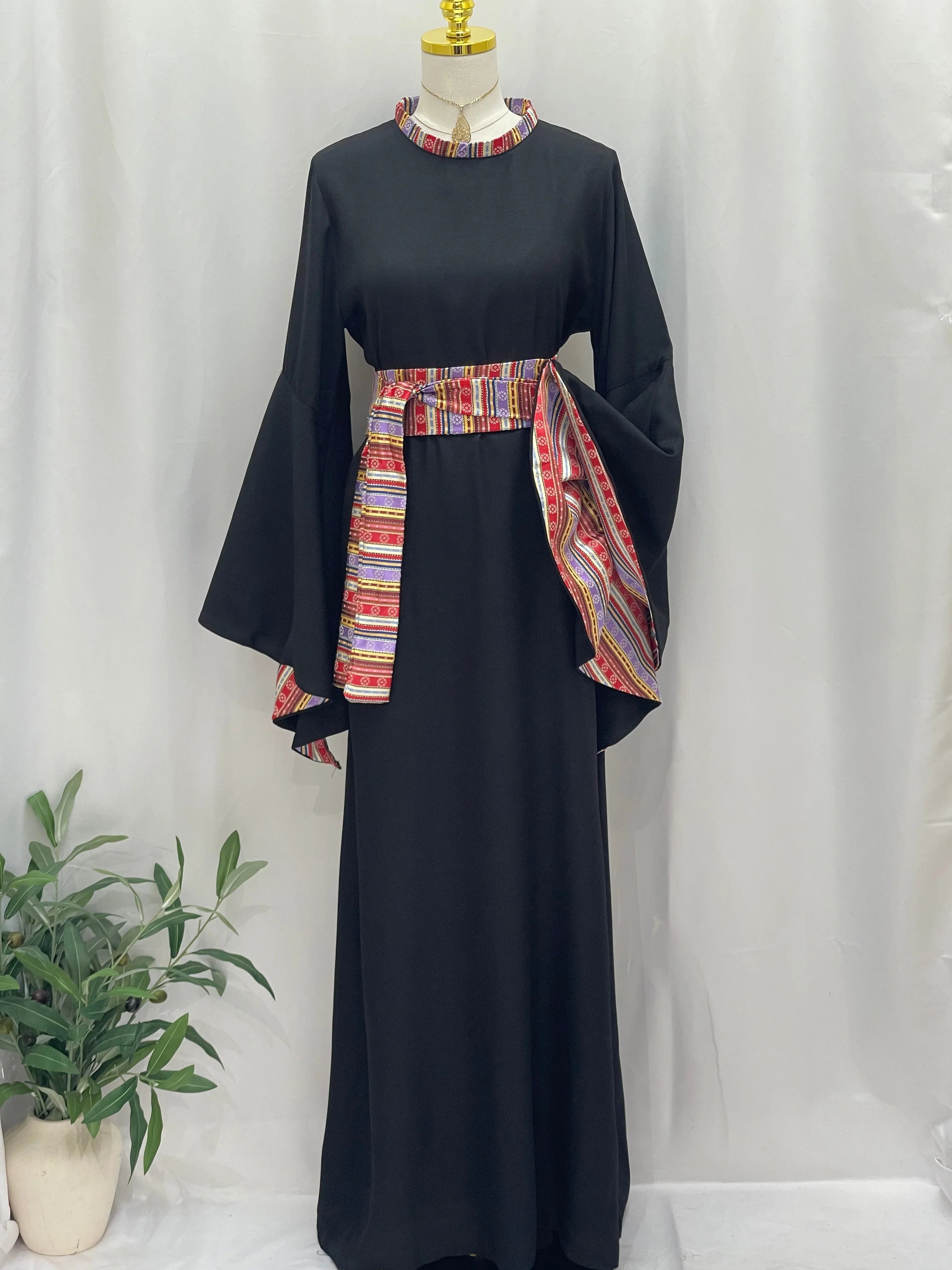 Palestinian Elegance Al-Mais Thobe in black with colorful embroidered belt and wide sleeves