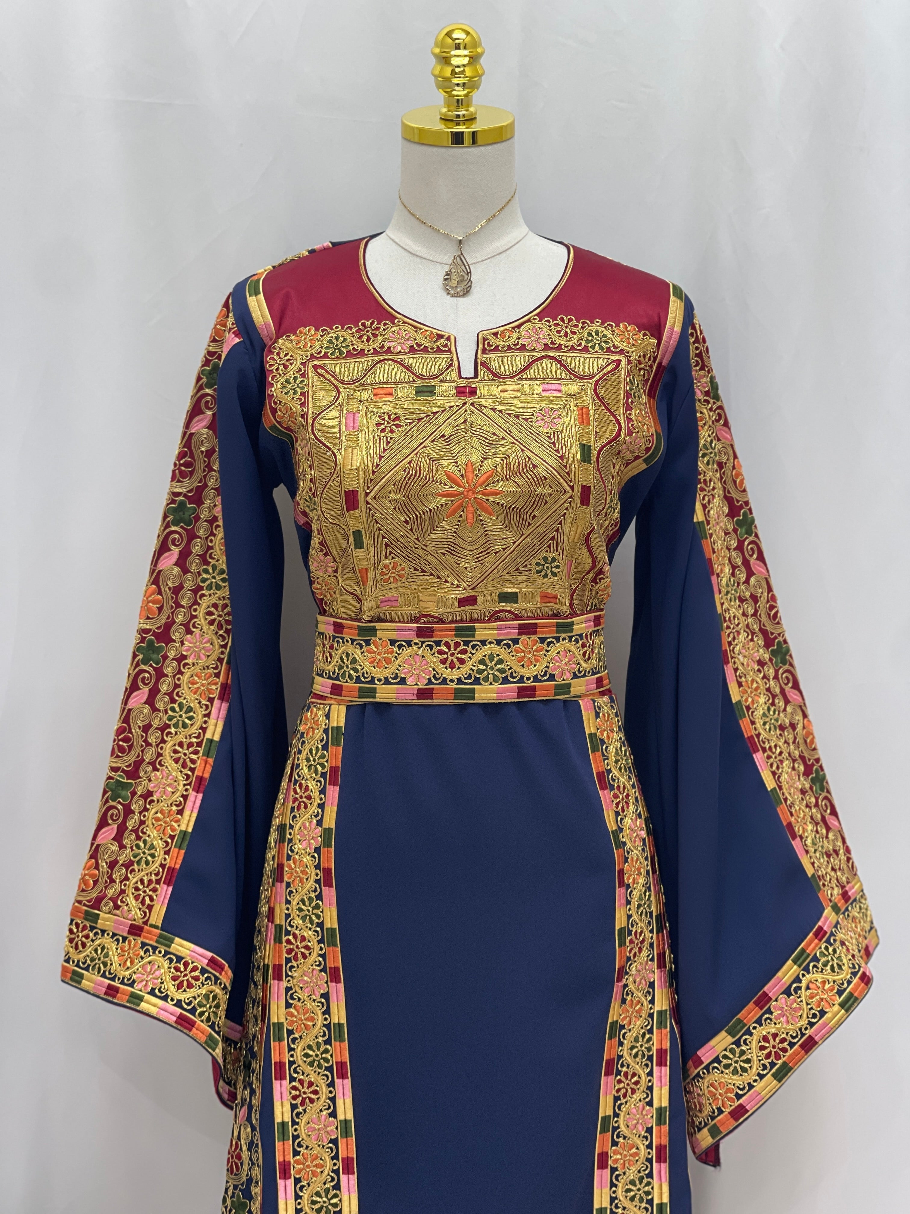 Al-Qasab Malaki Thobe in navy blue with intricate gold embroidery and stylish sleeves
