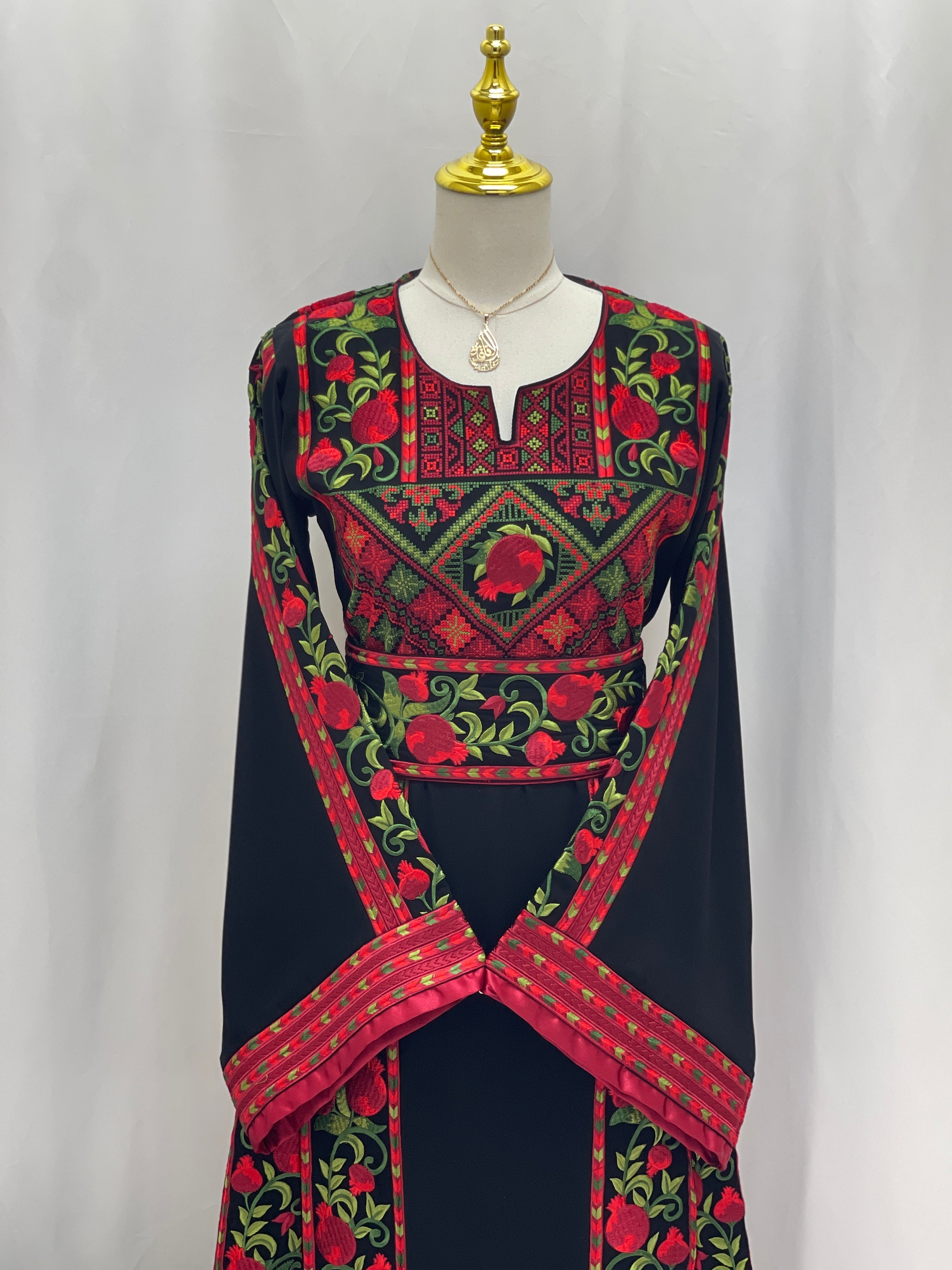 Palestinian Elegance Al Romana Pomegranate Embroidered Thoub with detailed red and green embroidery on black fabric