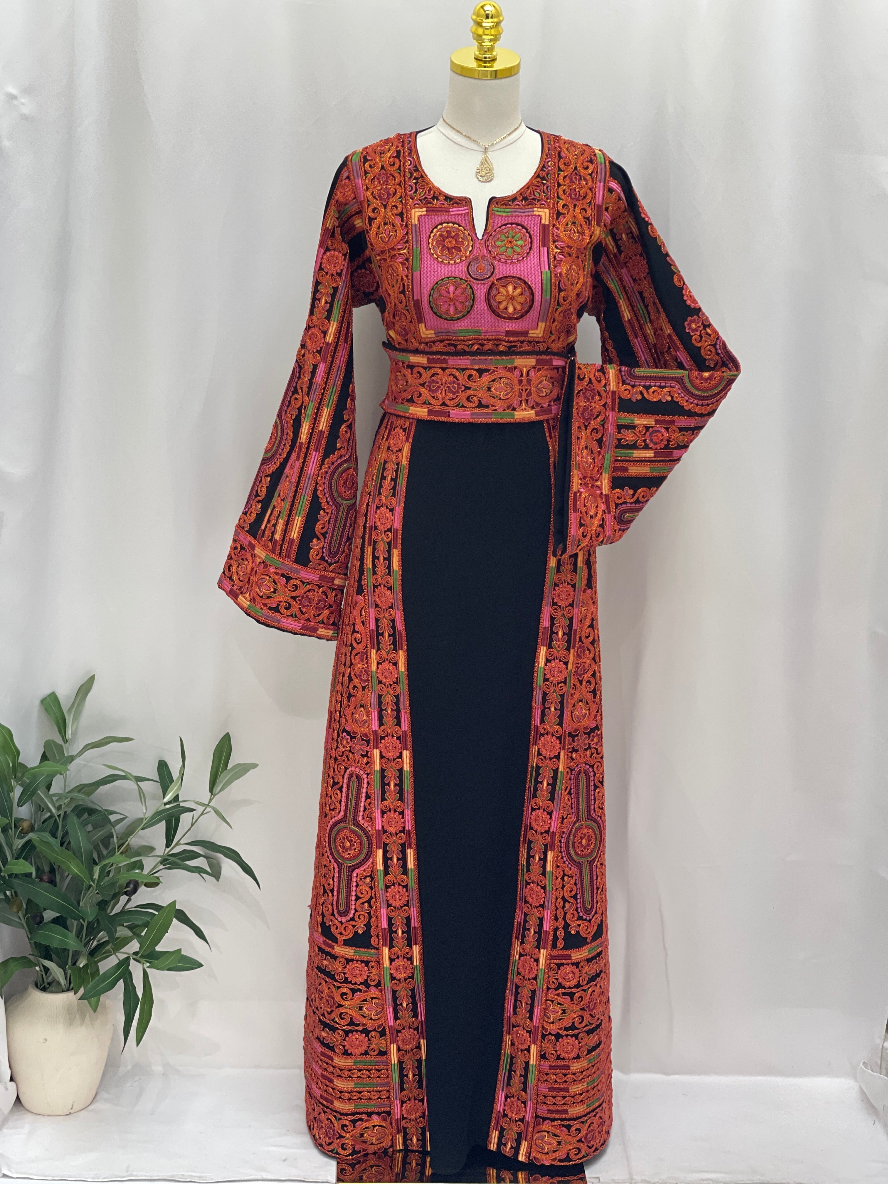 Al-Sundus Bream Embroidered Thobe by Palestinian Elegance black center with red orange embroidery and belt