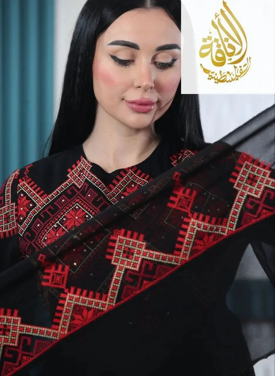 Modern embroidered Palestinian dress in black with detailed red embroidery worn by woman