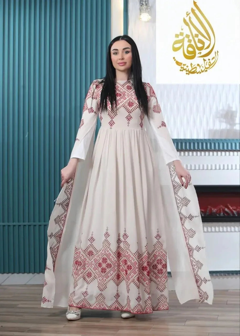 Modern embroidered Palestinian dress by Palestinian Elegance featuring intricate red embroidery on a flowing white fabric