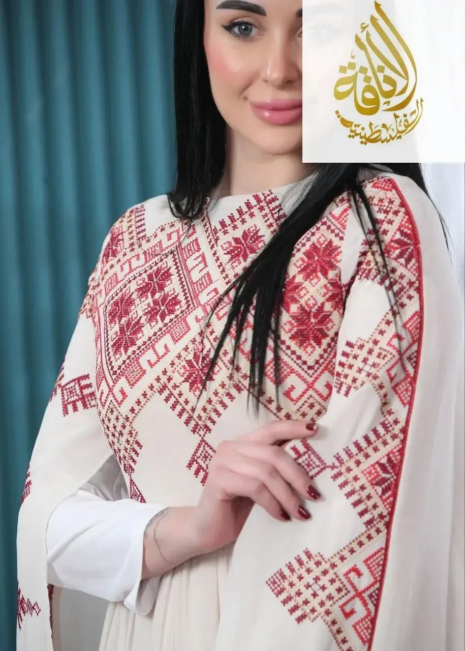 Modern embroidered Palestinian dress by Palestinian Elegance featuring detailed red embroidery on white fabric