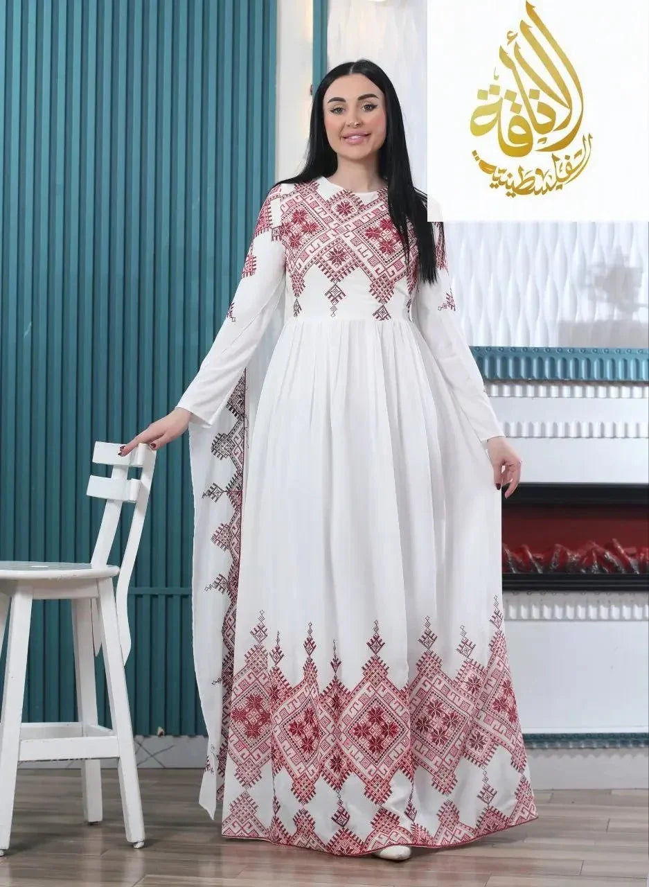 Modern embroidered Palestinian dress in white with red intricate embroidery worn by a woman