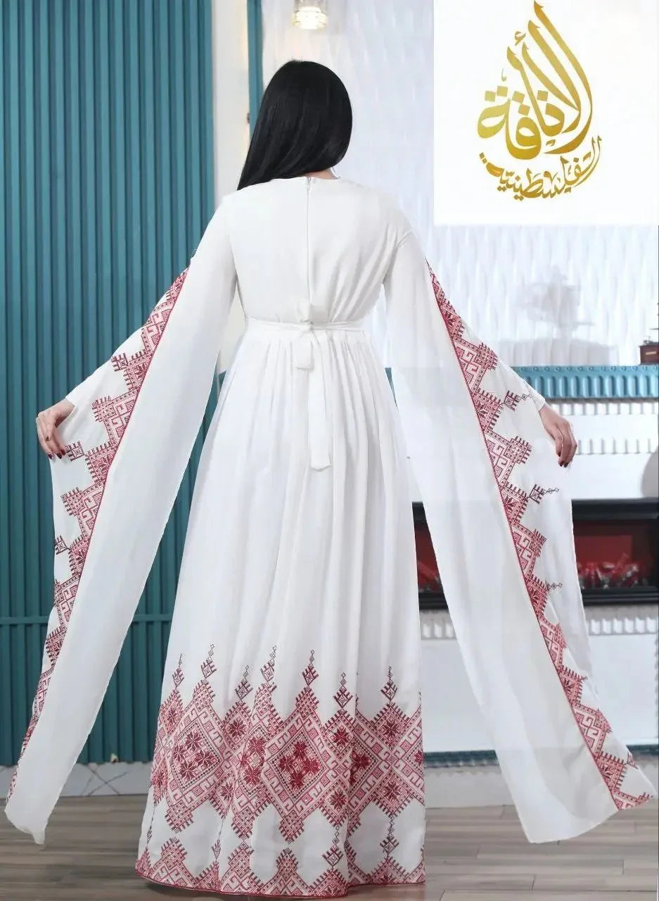 Modern embroidered Palestinian dress in white with intricate red embroidery on sleeves and hem by Palestinian Elegance