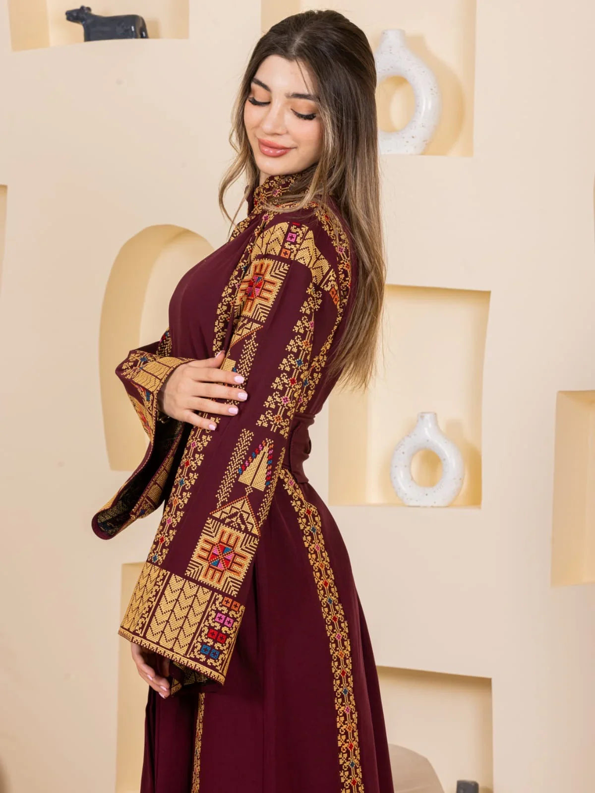 Asala Embroidered Thoub. Maroon embroidered thobe with gold cross stitch detail and long bell sleeves