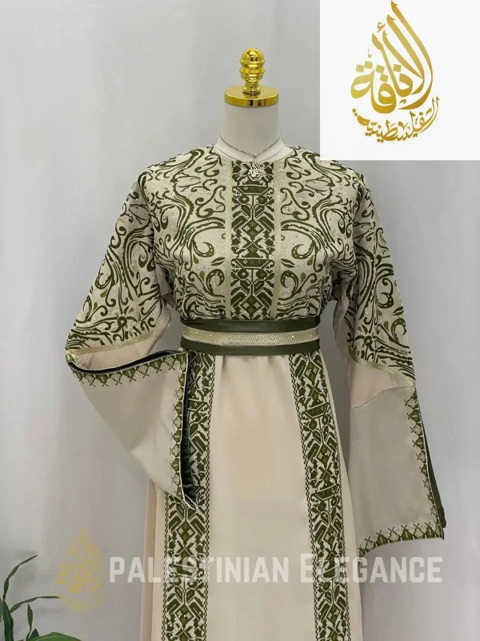 Palestinian embroidered thoub in cream with intricate green embroidery and wide sleeves display by Palestinian Elegance