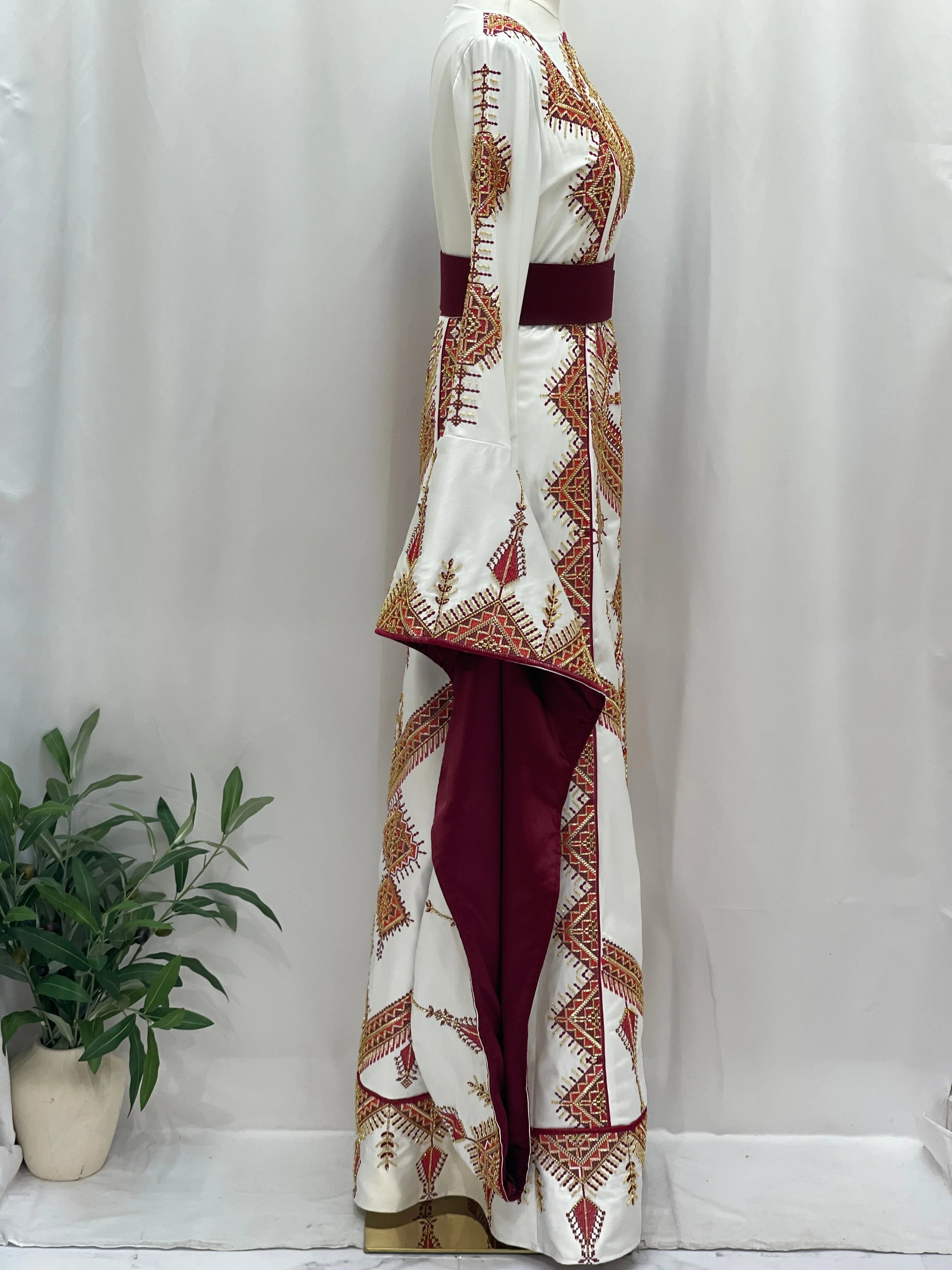 Orient Modren Embroidered Dress by Palestinian Elegance white embroidered thobe with maroon sash and gold geometric embroidery