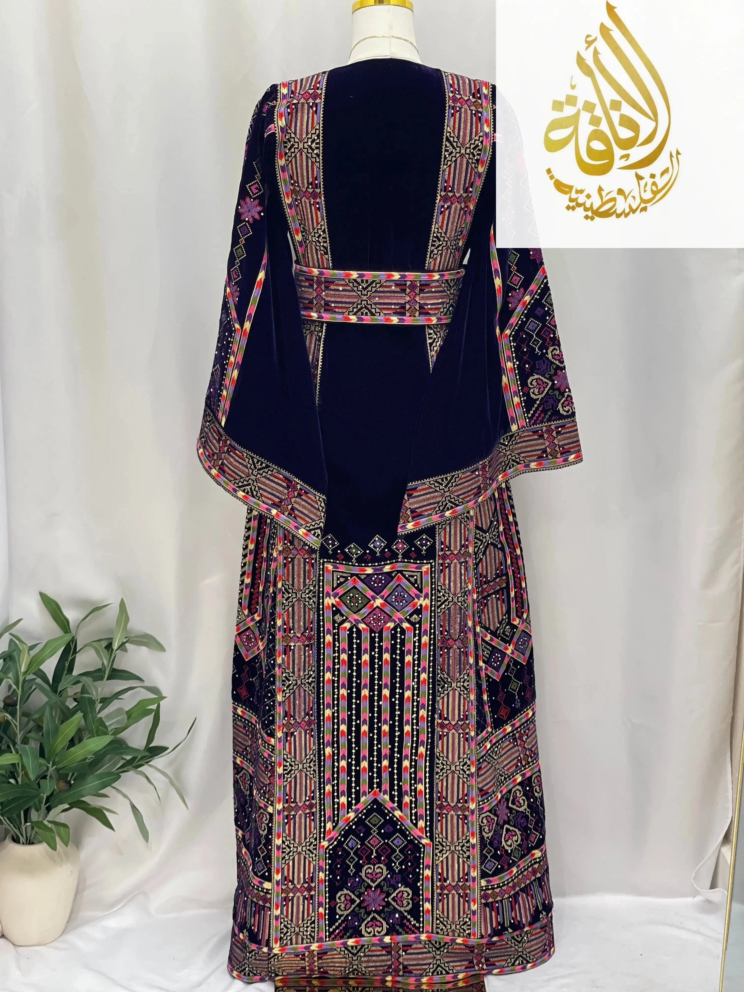 Back view of embroidered velvet thoub with intricate colorful Palestinian embroidery on dark velvet fabric