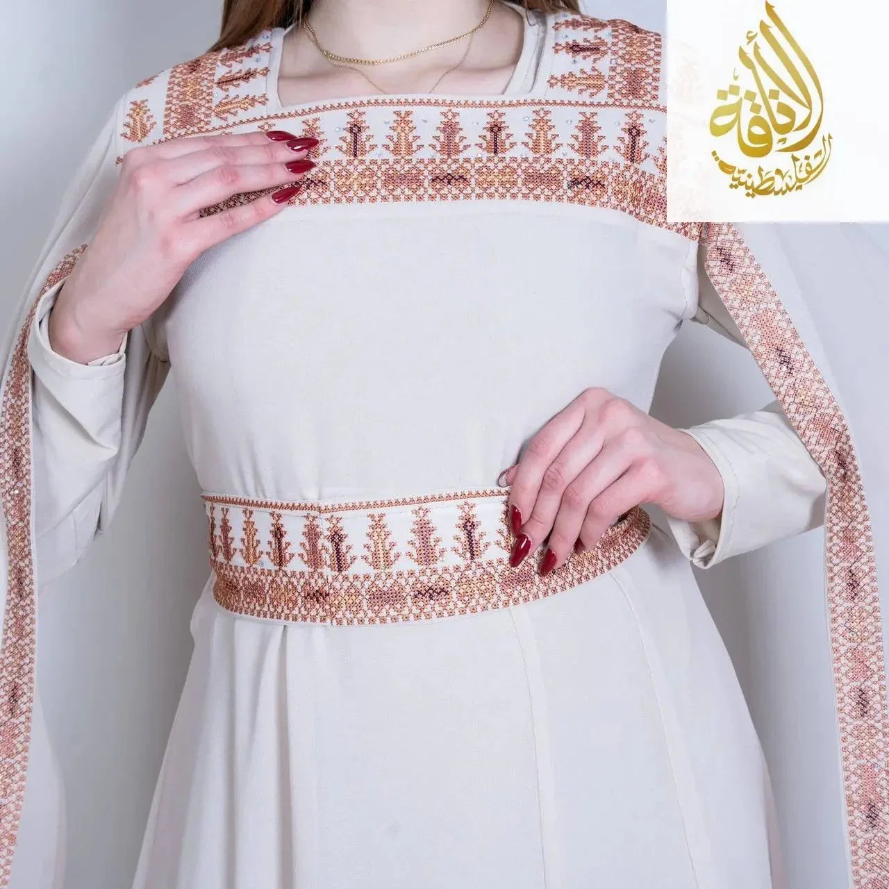 White embroidered Palestinian dress with detailed brown embroidery on chest, waist, and sleeves by Palestinian Elegance