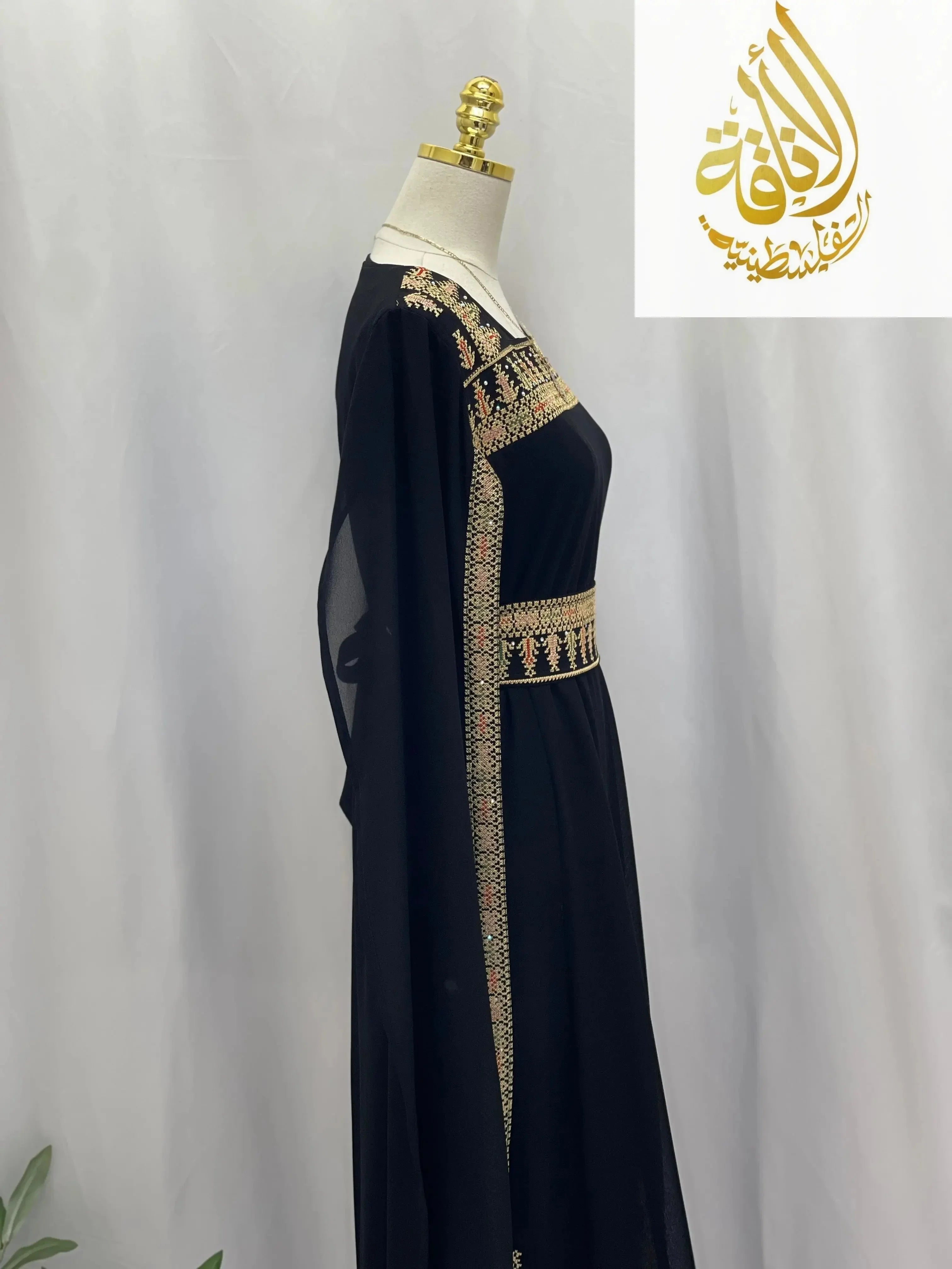 Black embroidered Palestinian dress showcasing intricate golden embroidery details on a mannequin by Palestinian Elegance