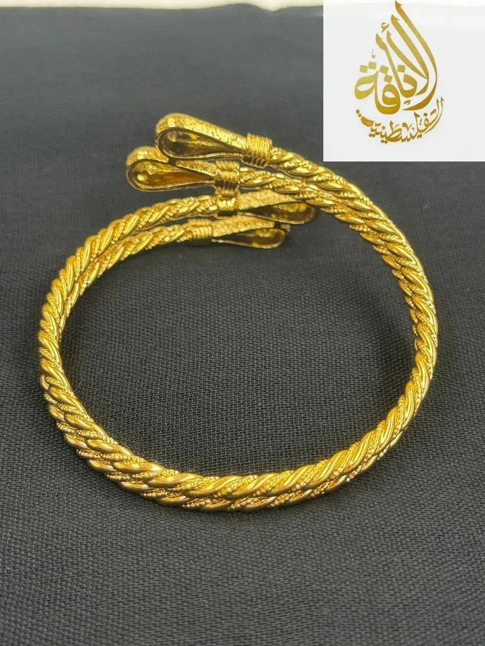 Palestinian Elegance imitated gold mabroume bracelet gold twist with detailed rope design on black background