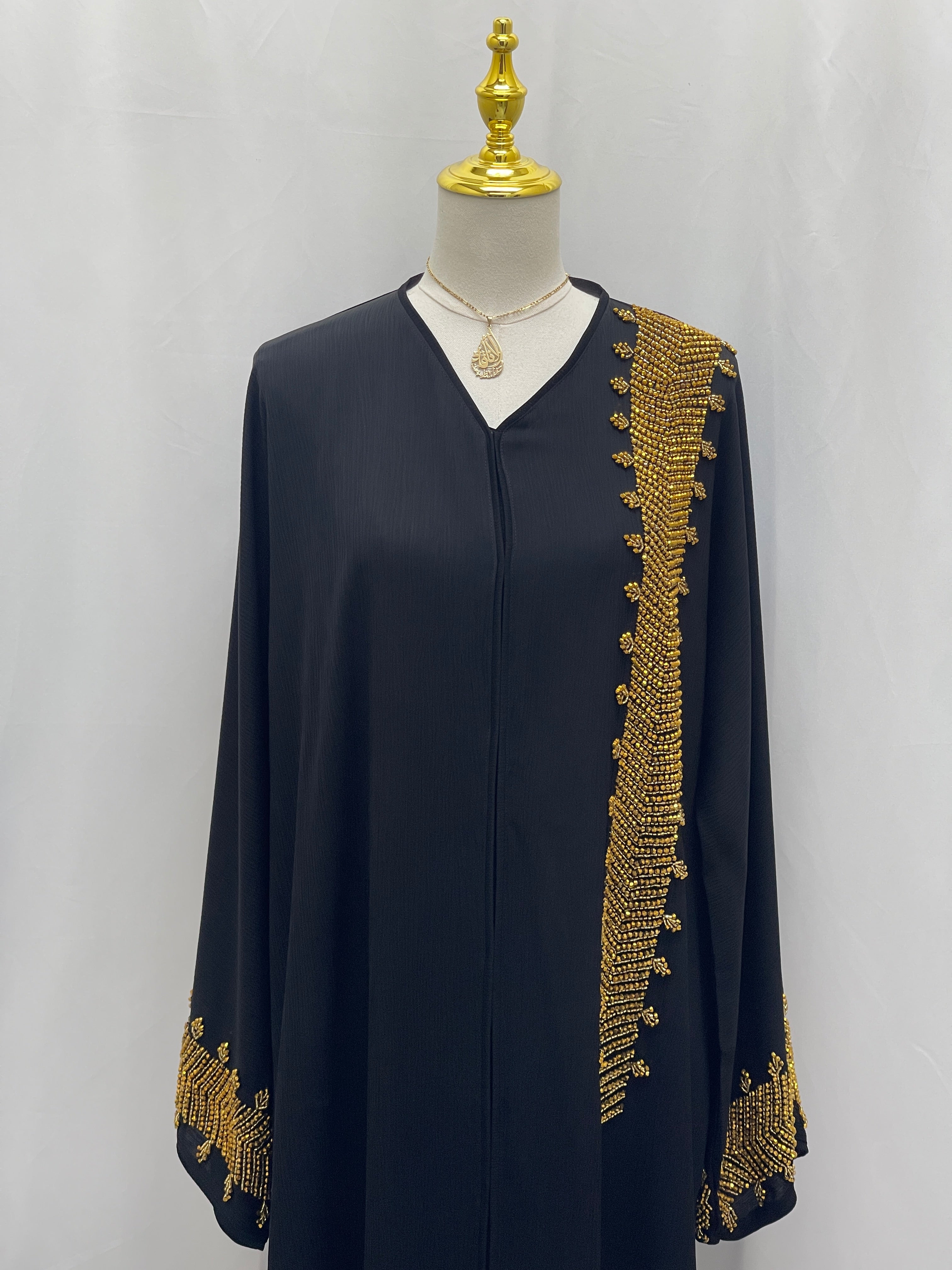 Black Palestinian Luxury Modest Fashion Abaya with intricate gold embroidery on sleeves and front
