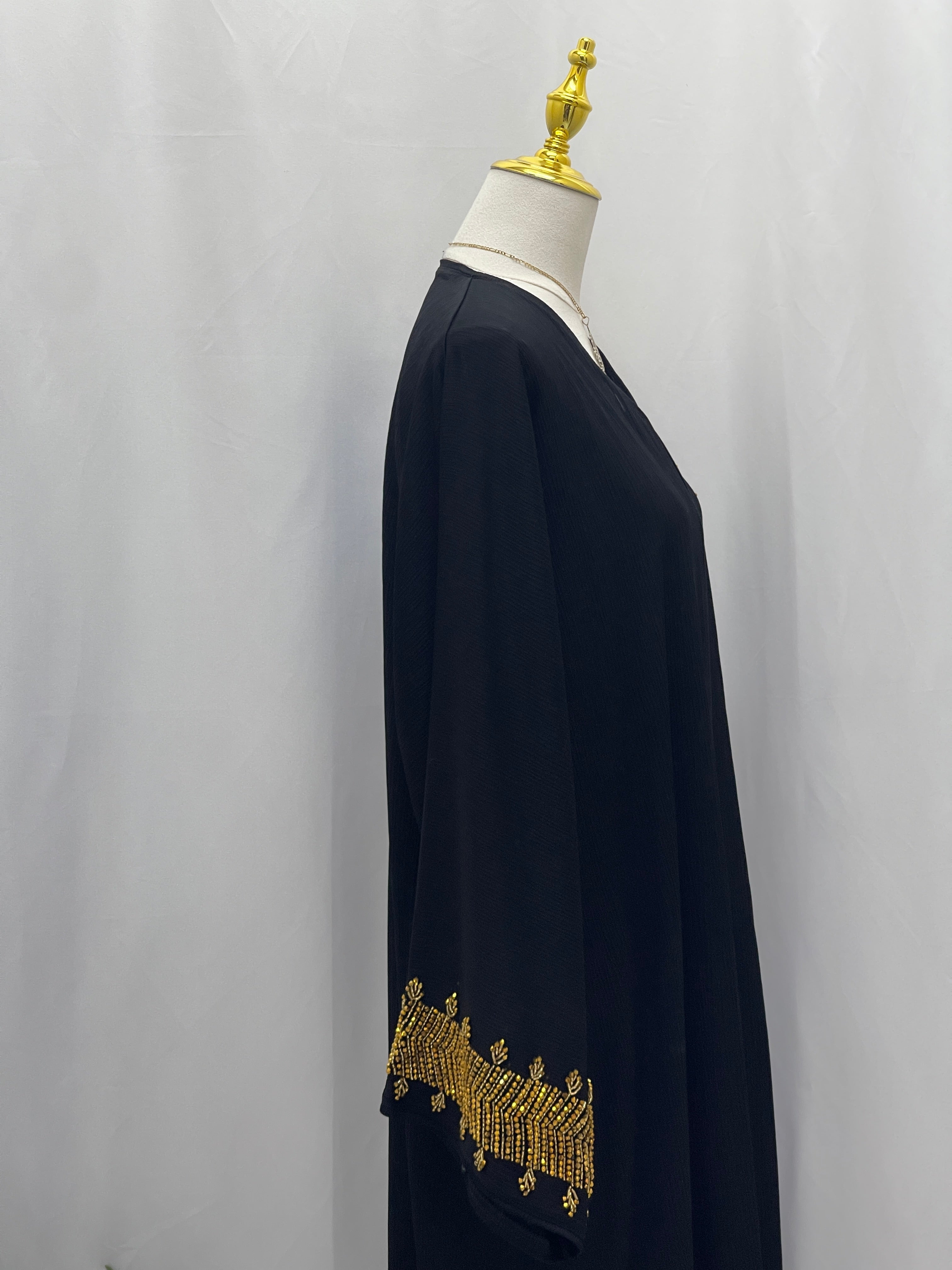 Black abaya with gold detailed embroidery on sleeves from Palestinian Luxury Modest Fashion Abaya collection