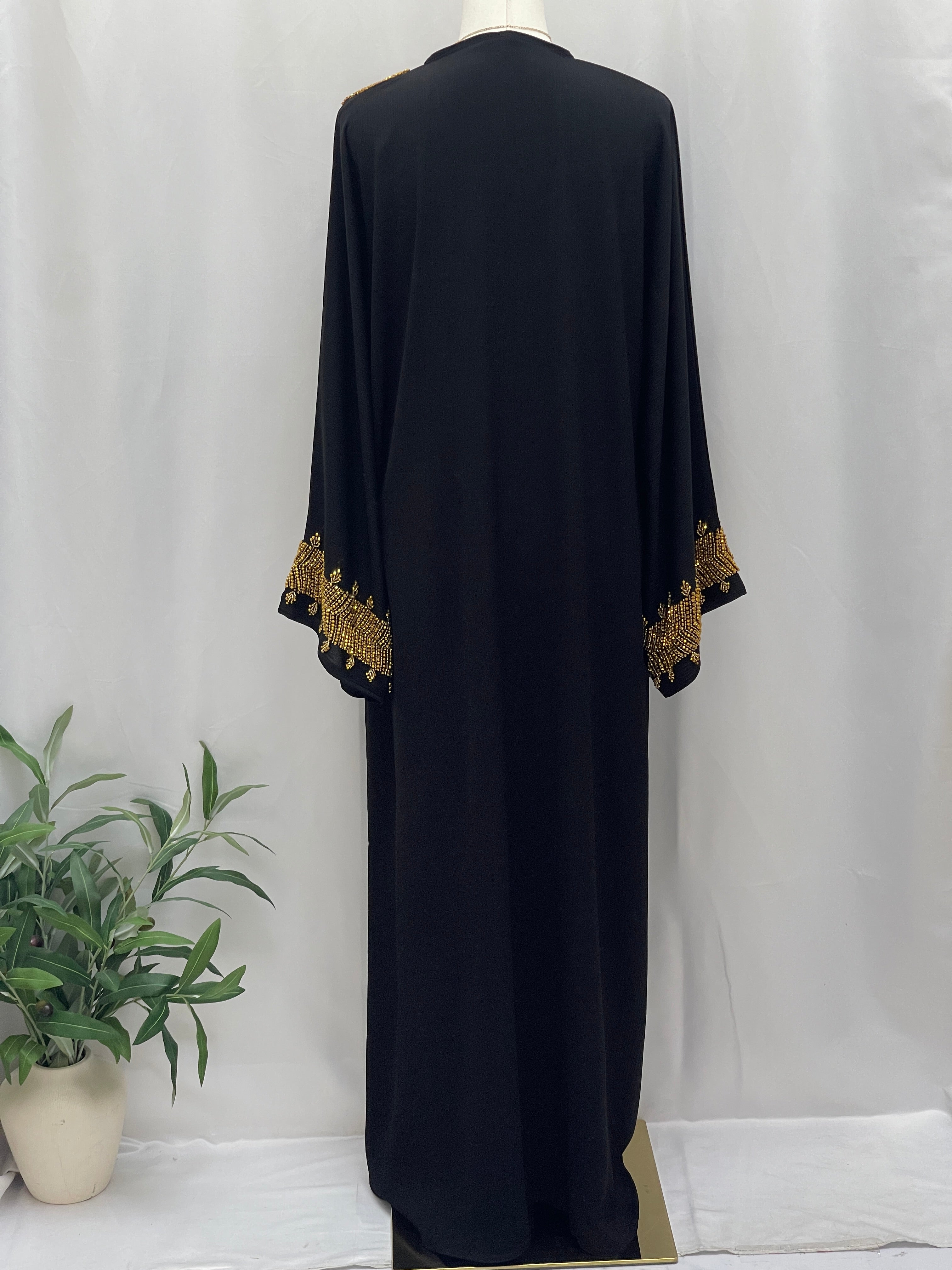 Palestinian Luxury Modest Fashion Abaya in black with intricate gold embroidery on sleeves by Palestinian Elegance
