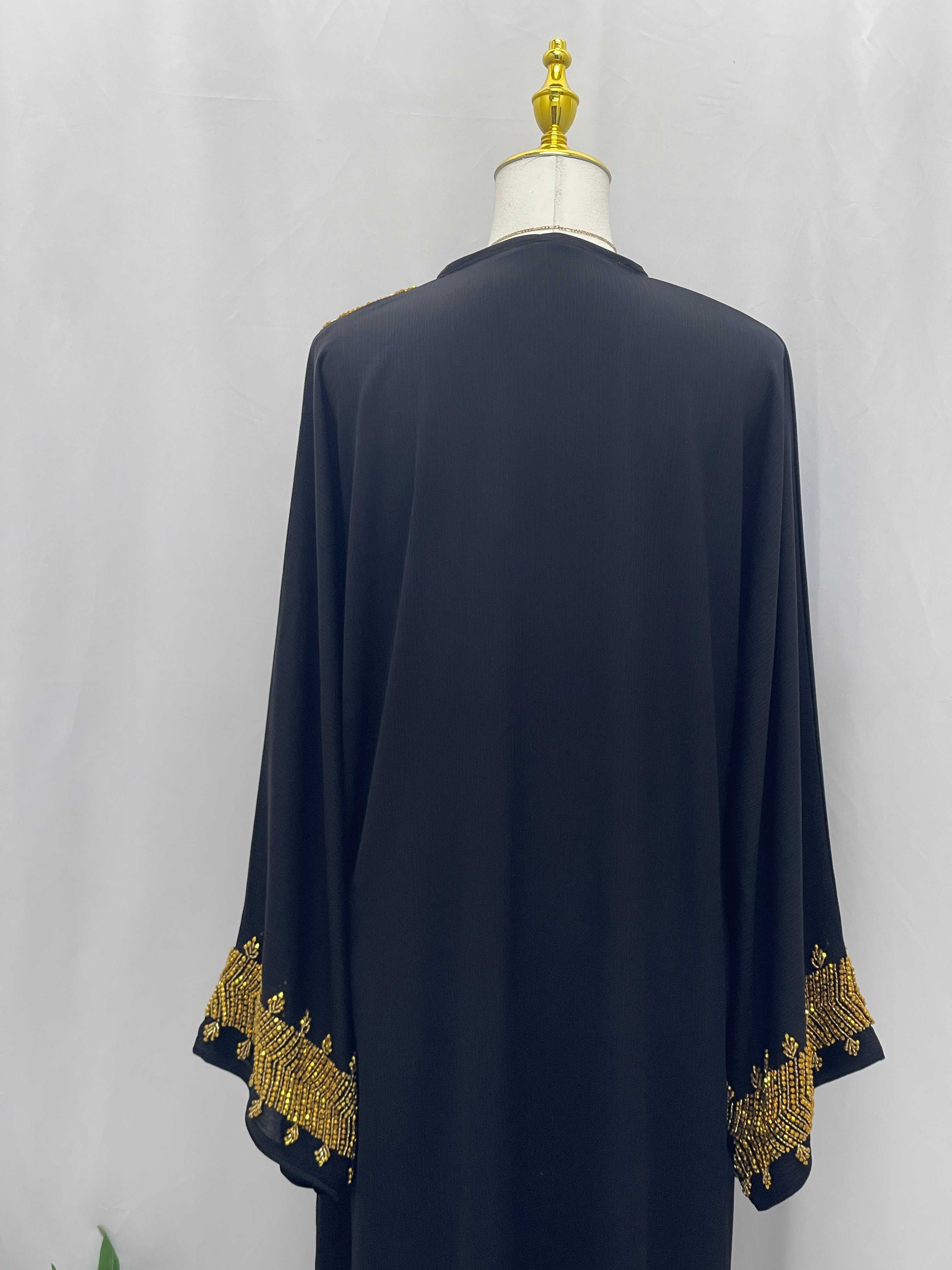Back view of a black abaya with gold embroidery on sleeves from Palestinian Luxury Modest Fashion Abaya collection