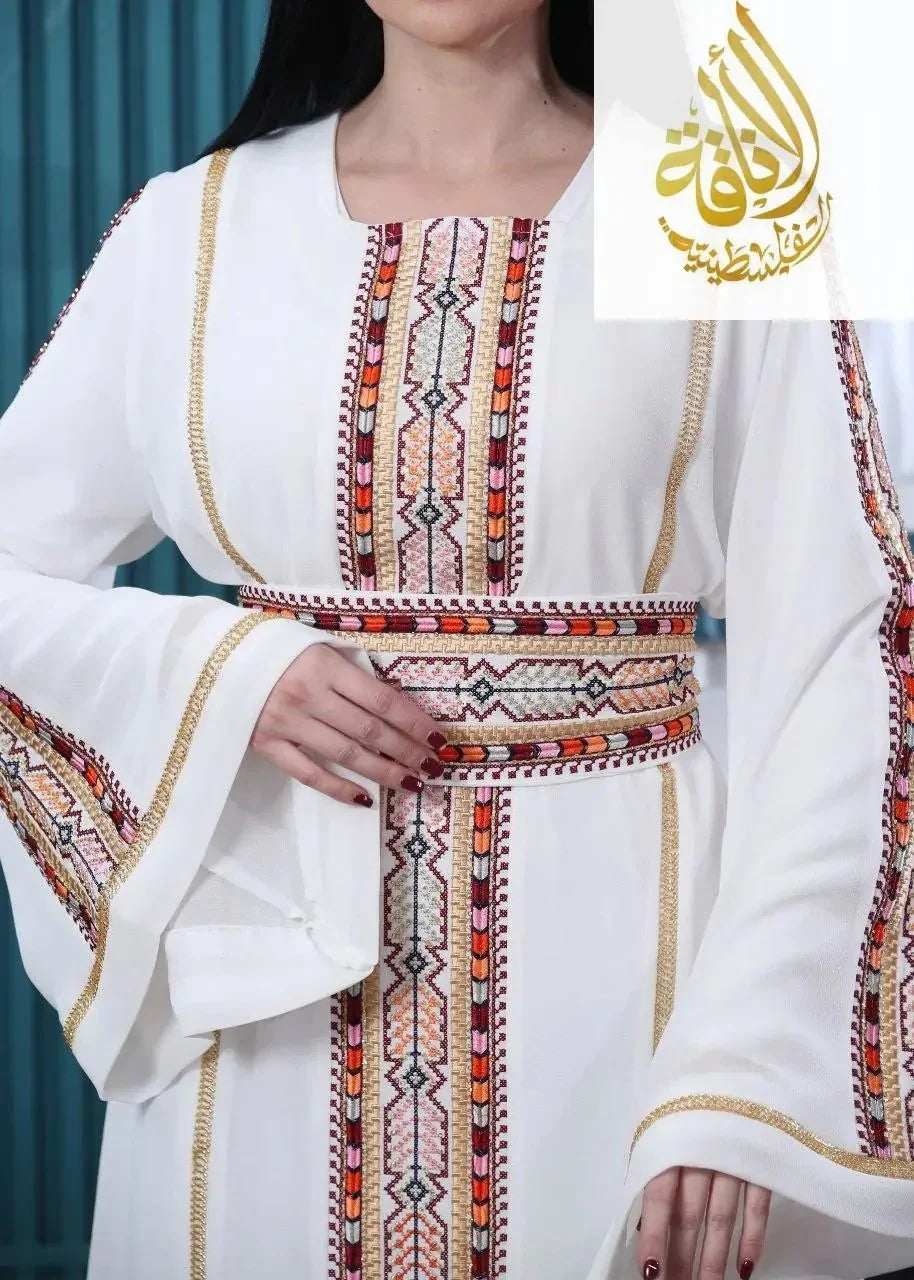 White embroidered Palestinian kaftan with intricate traditional patterns and wide sleeves by Palestinian Elegance
