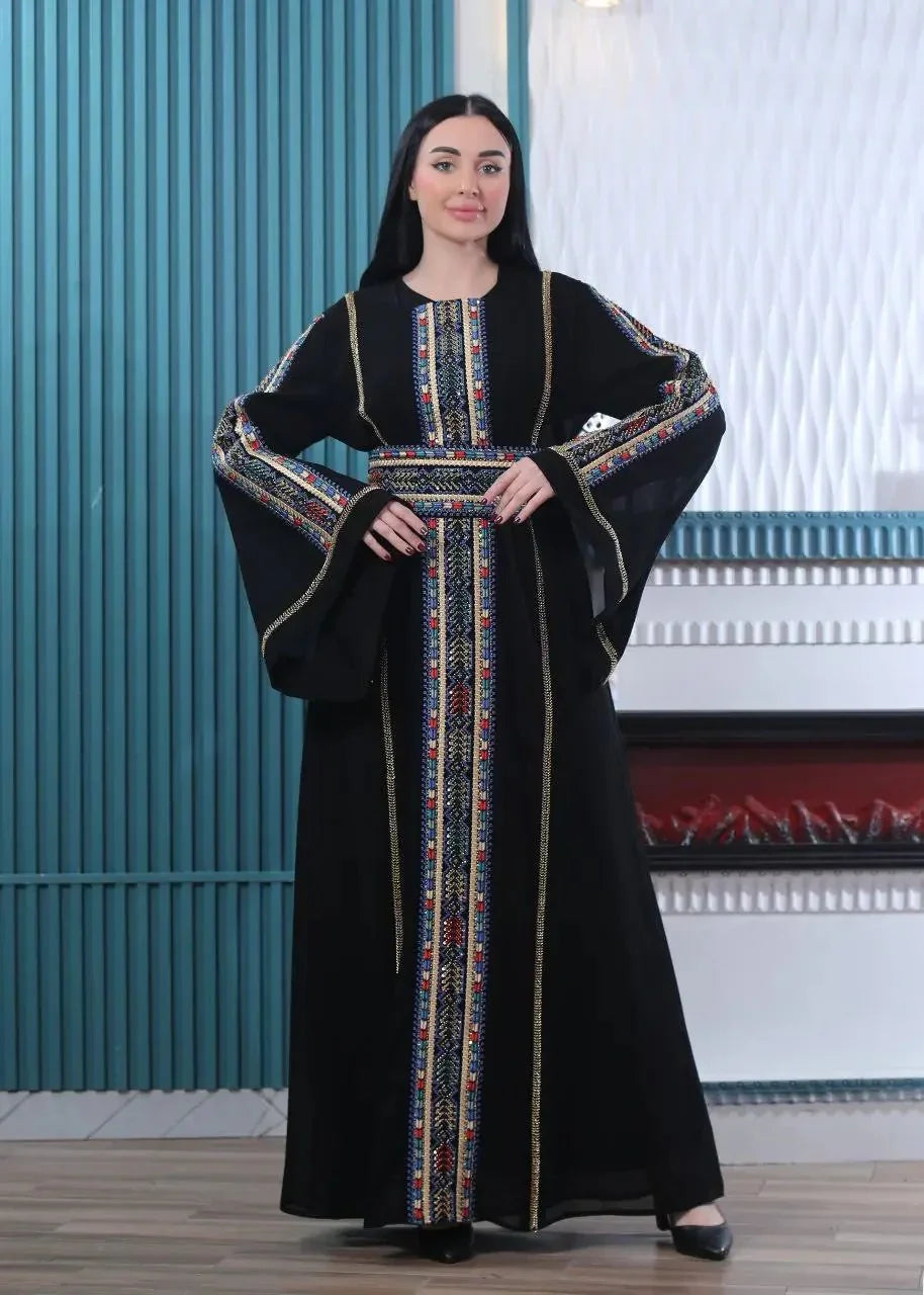 Black embroidered Palestinian kaftan with colorful traditional stitching worn by woman from Palestinian Elegance