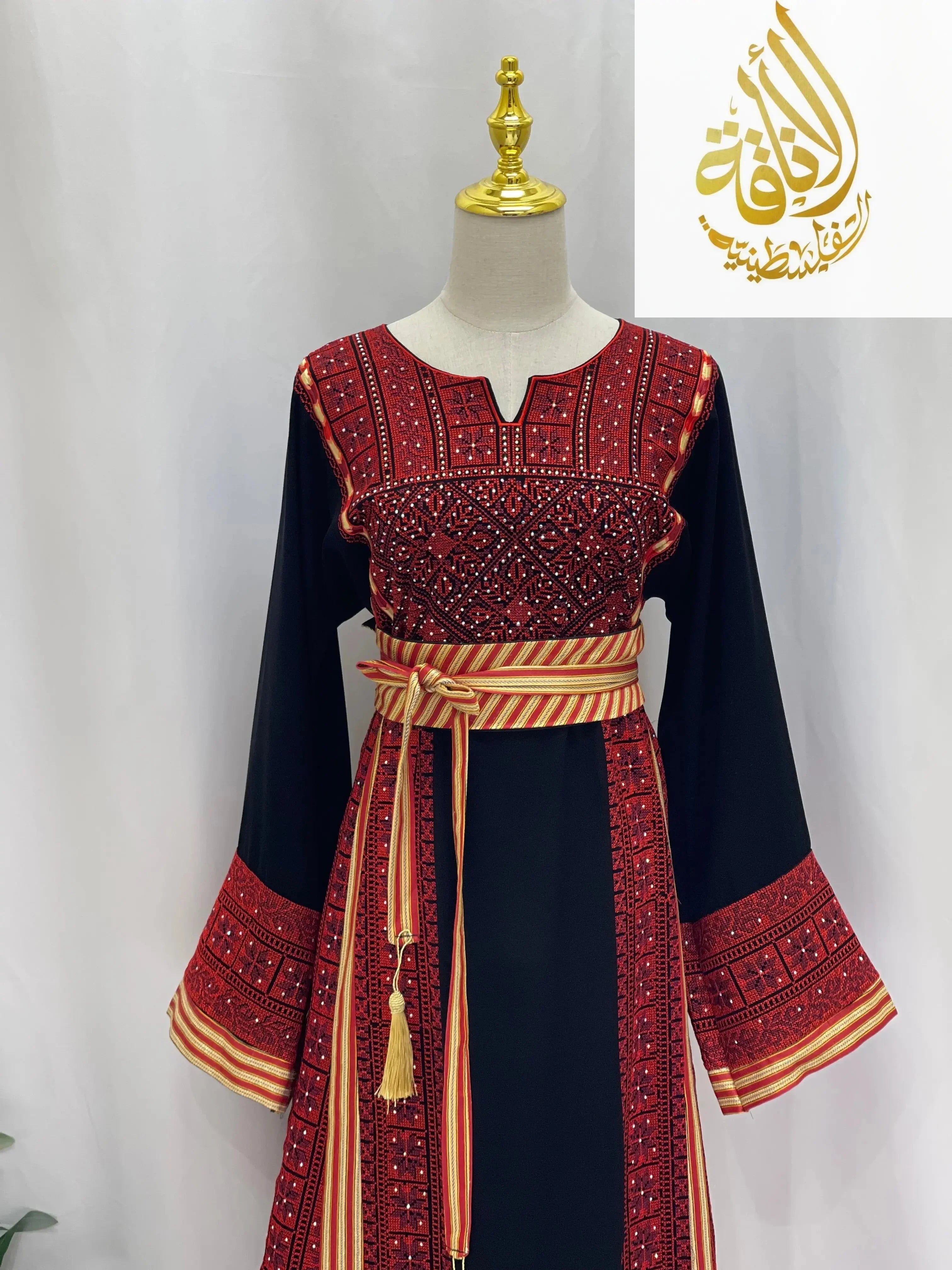 Embroidered Palestinian thoub dress with intricate red and black embroidery and striped waist belt