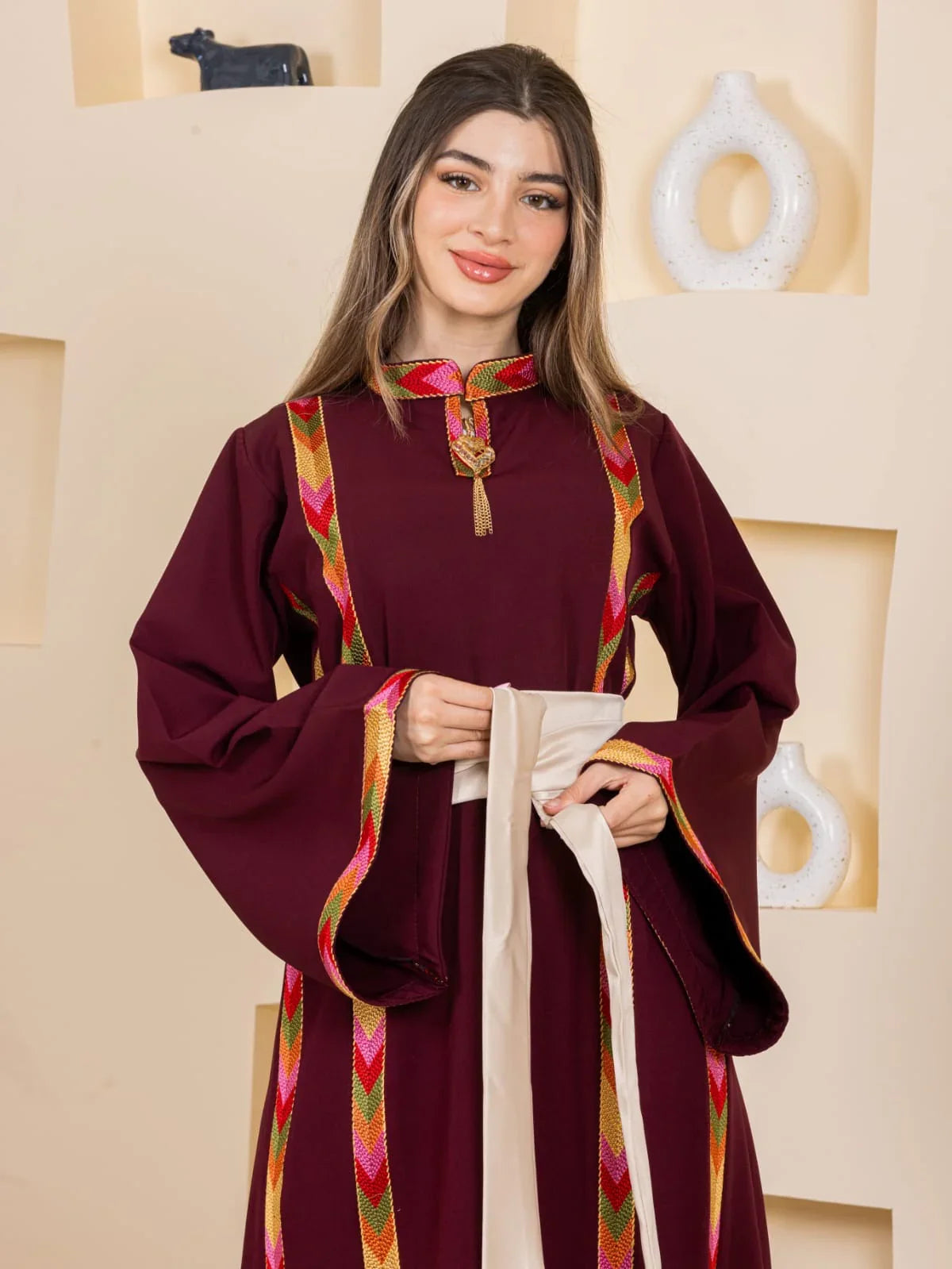Palestinian Elegance maroon embroidered thobe with colorful chevron trim and beige sash Embroiderd Thoub Al-Manajel