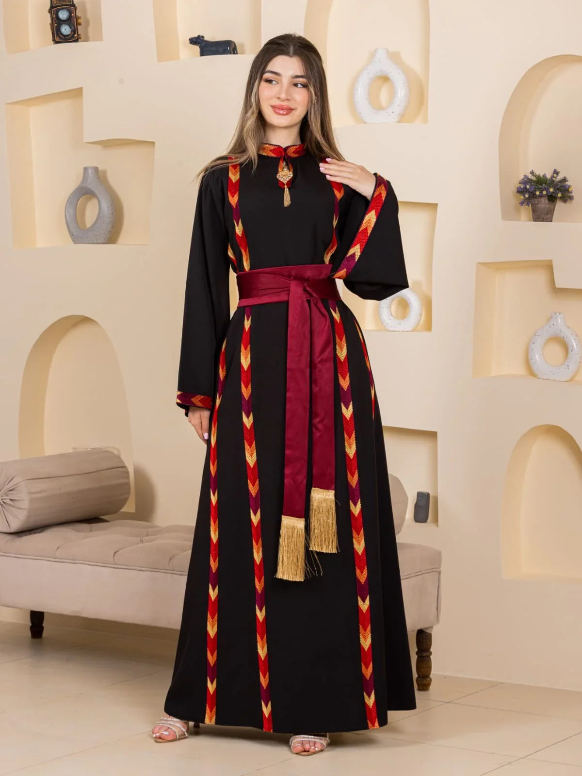 Palestinian Elegance Embroiderd Thoub Al-Manajel black thobe with red and gold chevron embroidery and maroon sash
