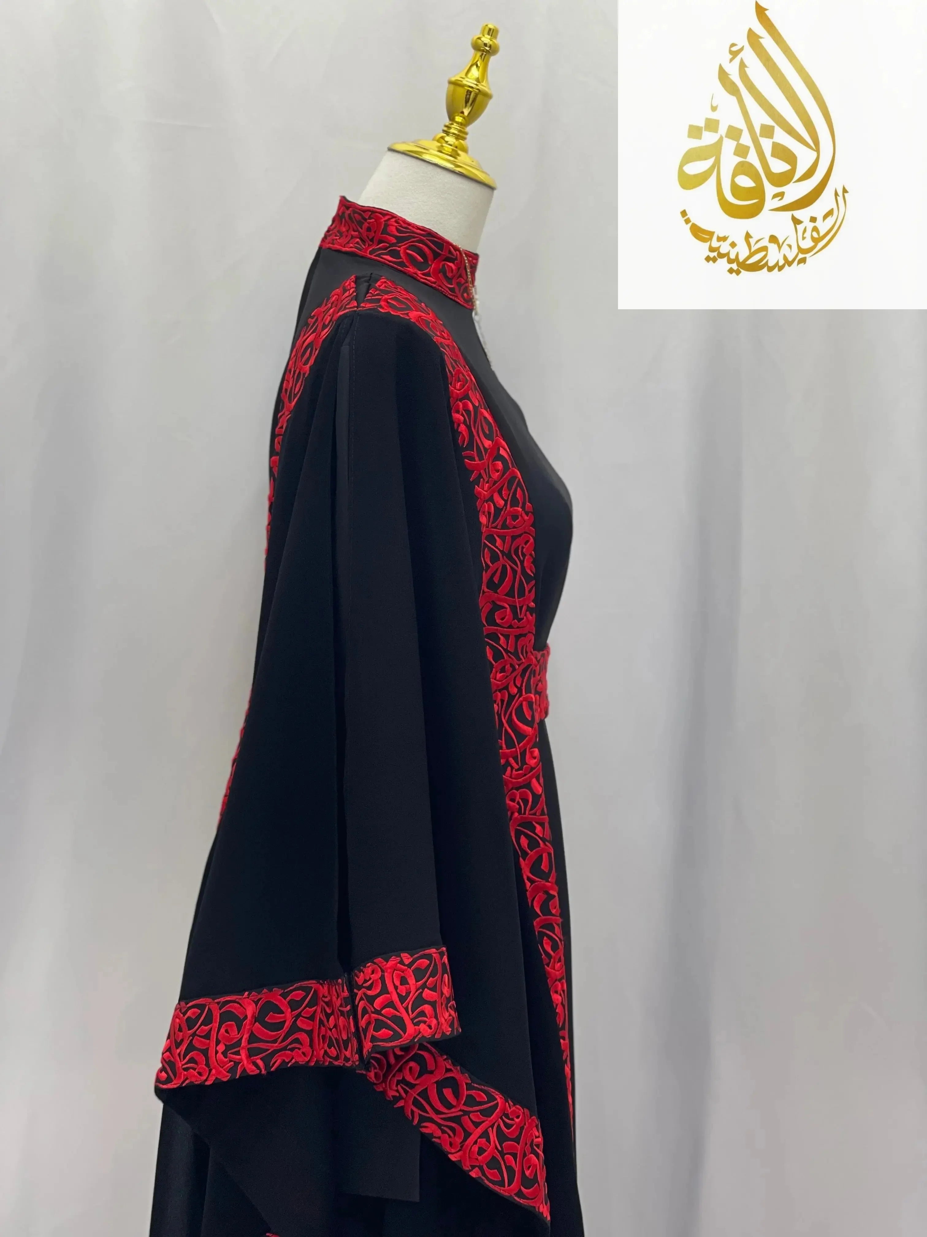 Embroidered abaya with Arabic letters in black featuring red intricate embroidery on sleeves and collar by Palestinian Elegance
