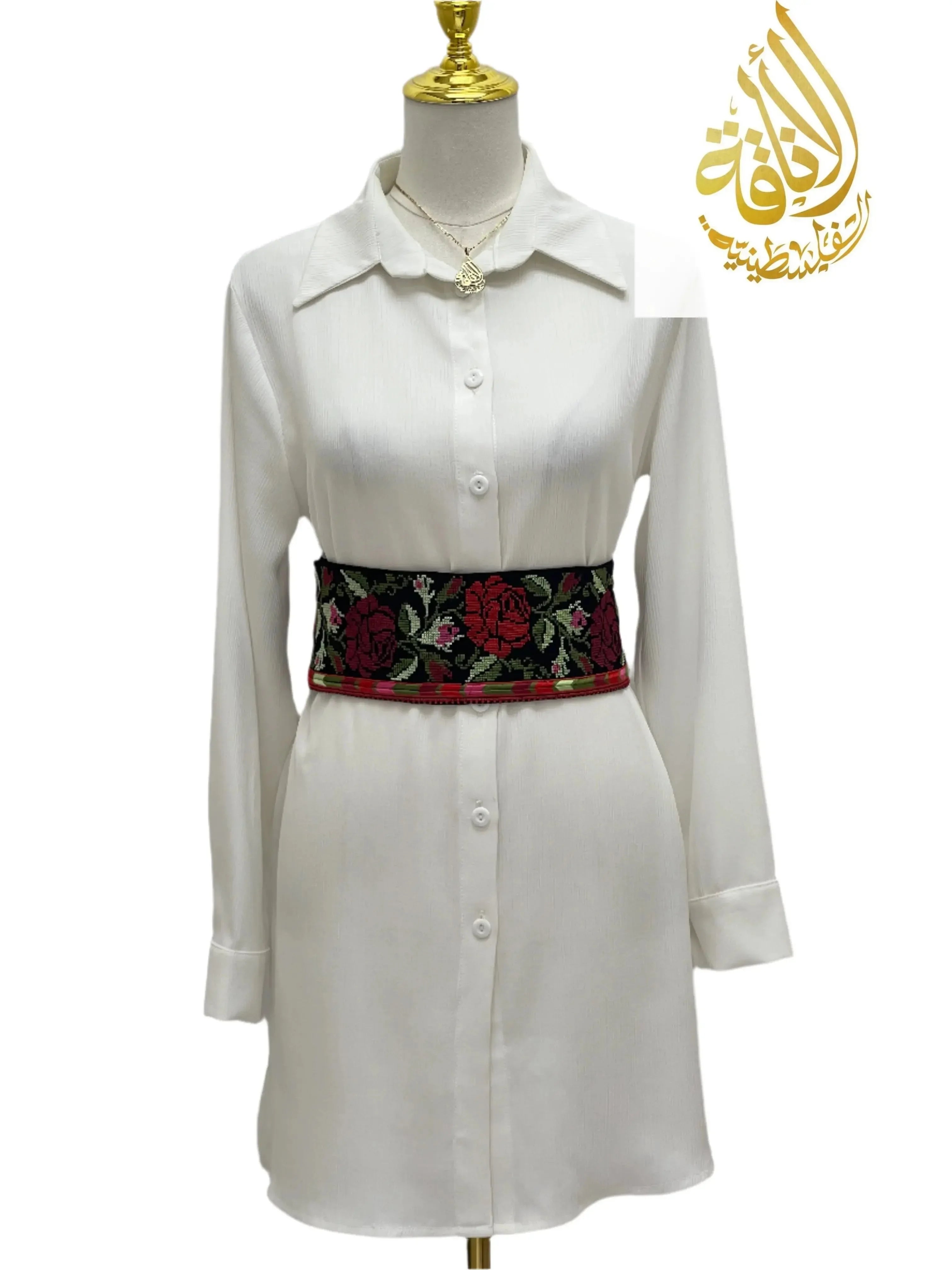 Embroidered Heritage Belt by Palestinian Elegance with red and green floral design on black background styled on white dress