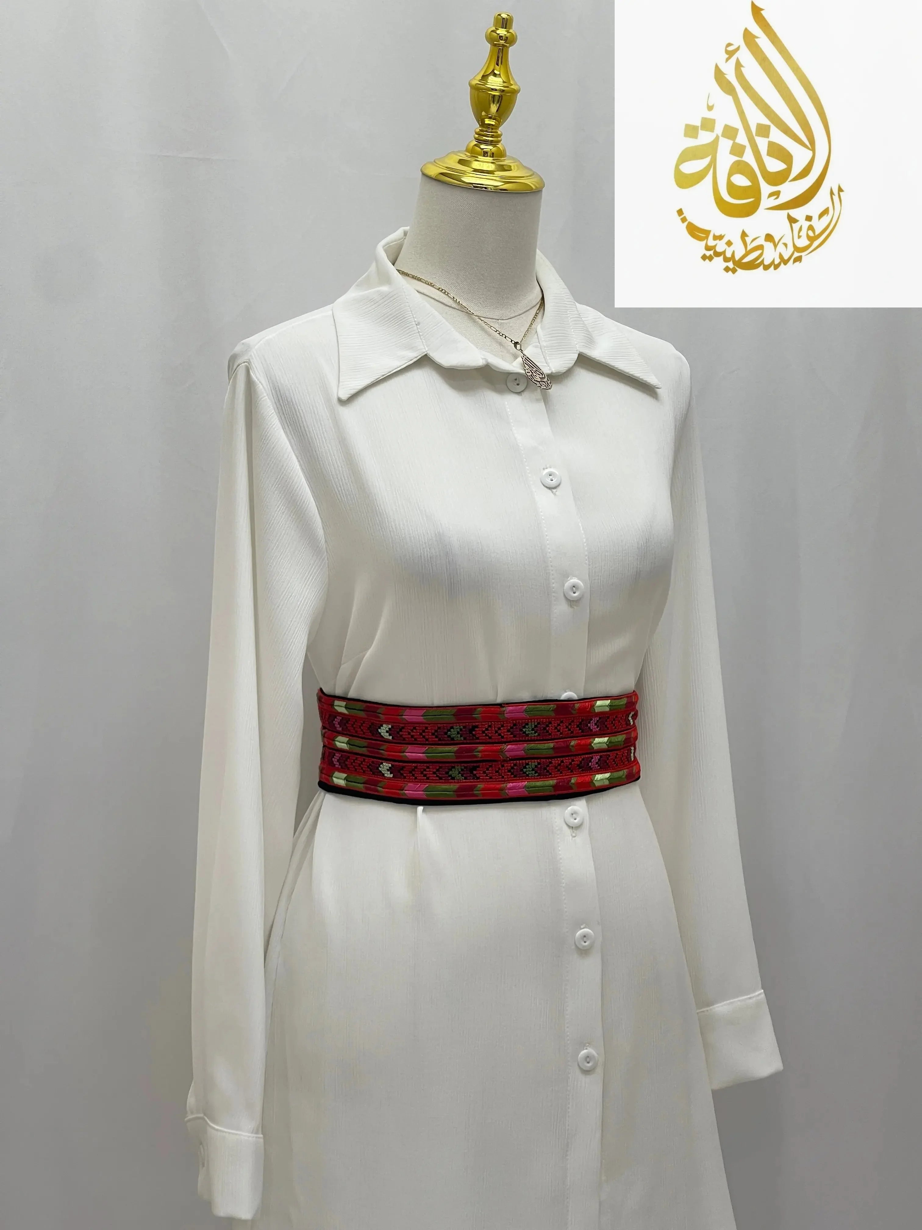 Palestinian Elegance Embroidered Heritage Belt in red with traditional patterns worn over white long sleeve dress