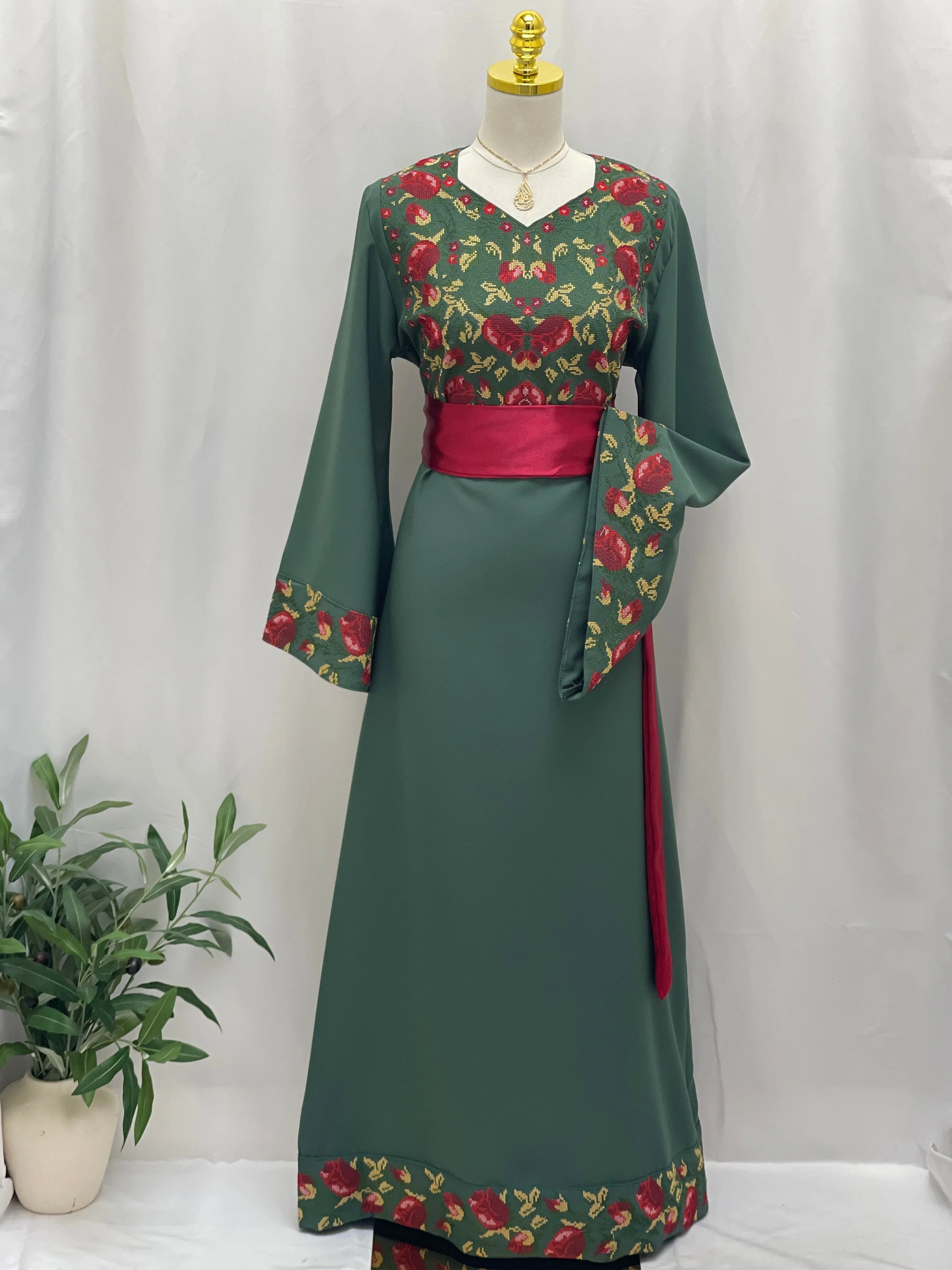 Emerald Blossom EmbroideredThobe Palestinian Elegance green embroidered thobe with red waist sash and floral trim