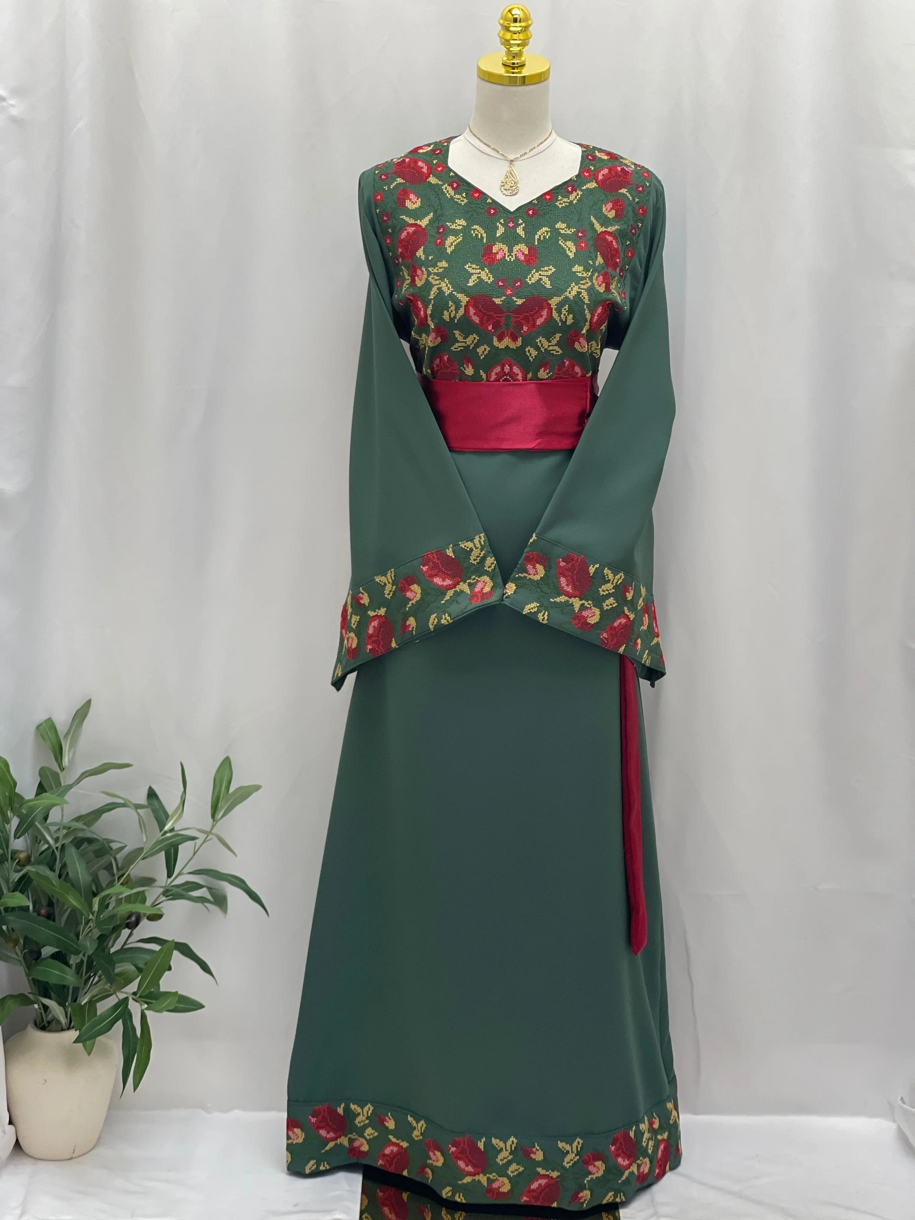 Emerald Blossom EmbroideredThobe by Palestinian Elegance green thobe with red floral embroidery wide cuffs and sash